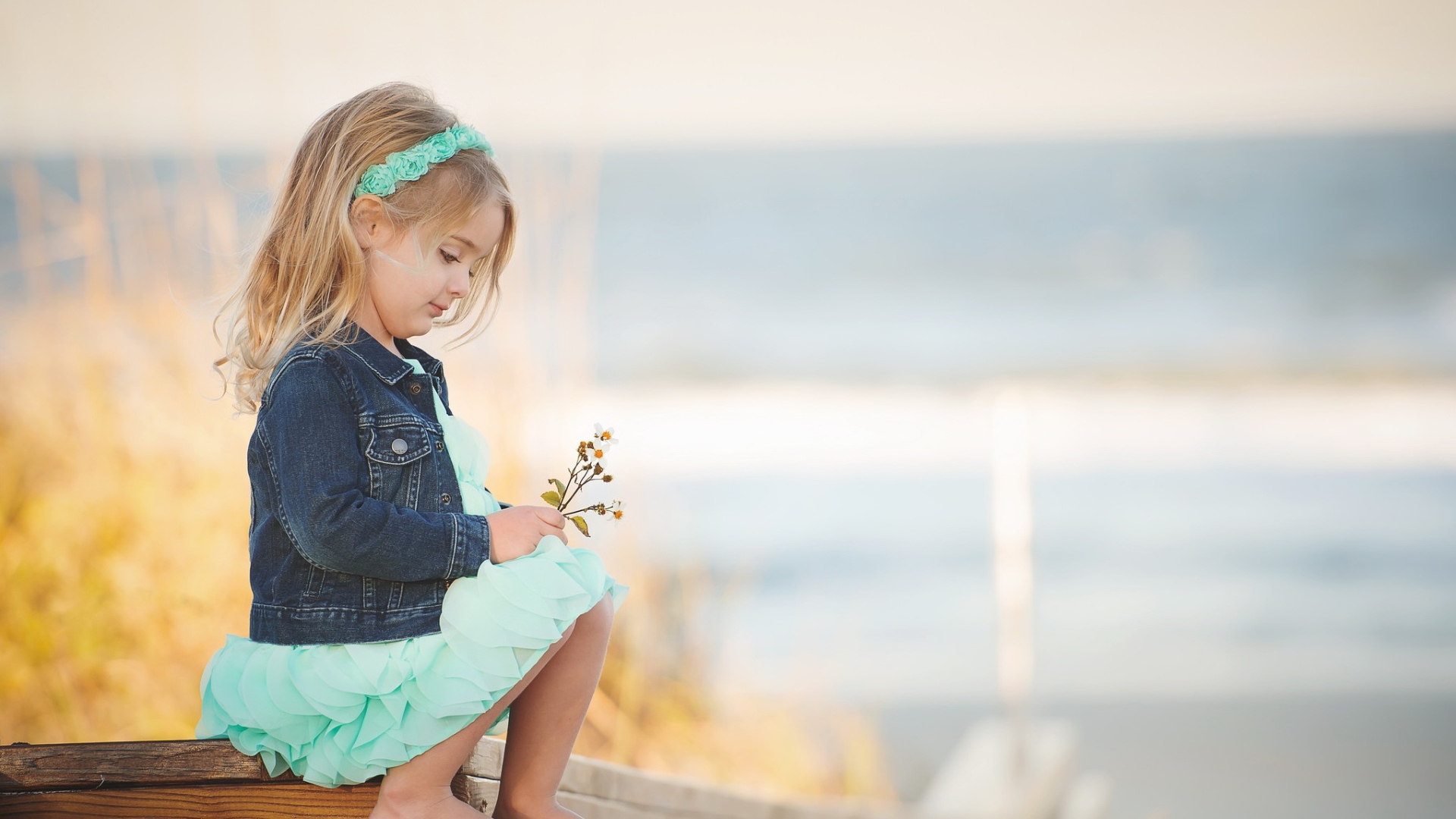 Маленькая девочка сидит на мосту