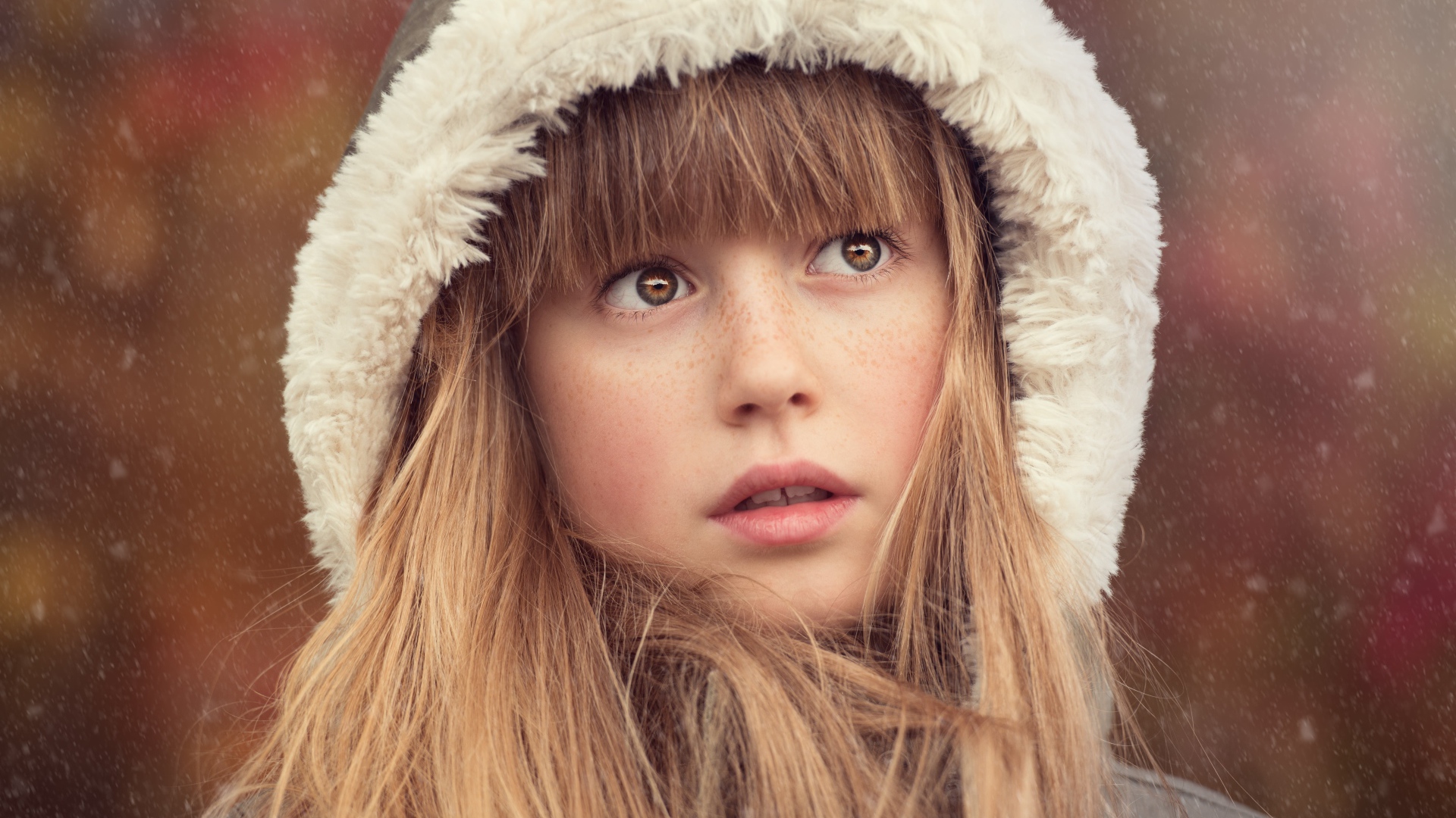 Маленькая девочка с веснушками на лице в капюшоне 