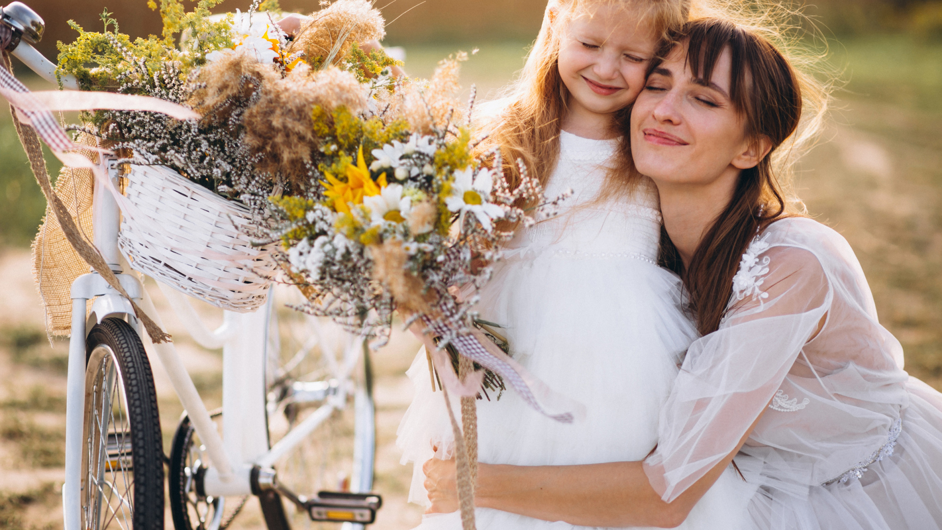 Маленькая девочка с мамой у велосипеда