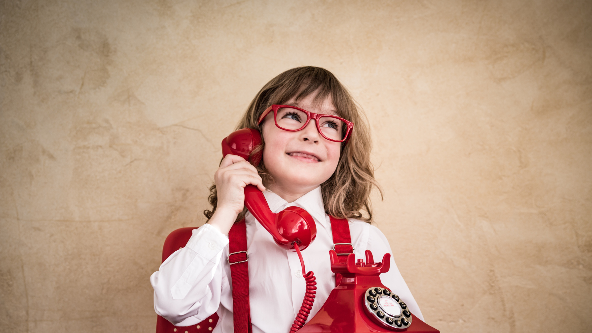 Улыбающийся мальчик с красным телефоном