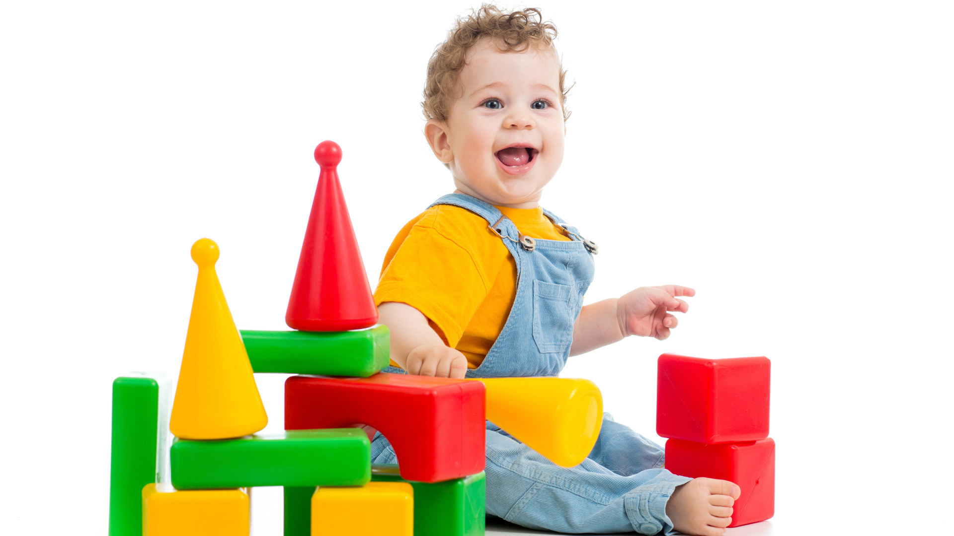 Улыбающийся милый малыш играет с кубиками на белом фоне