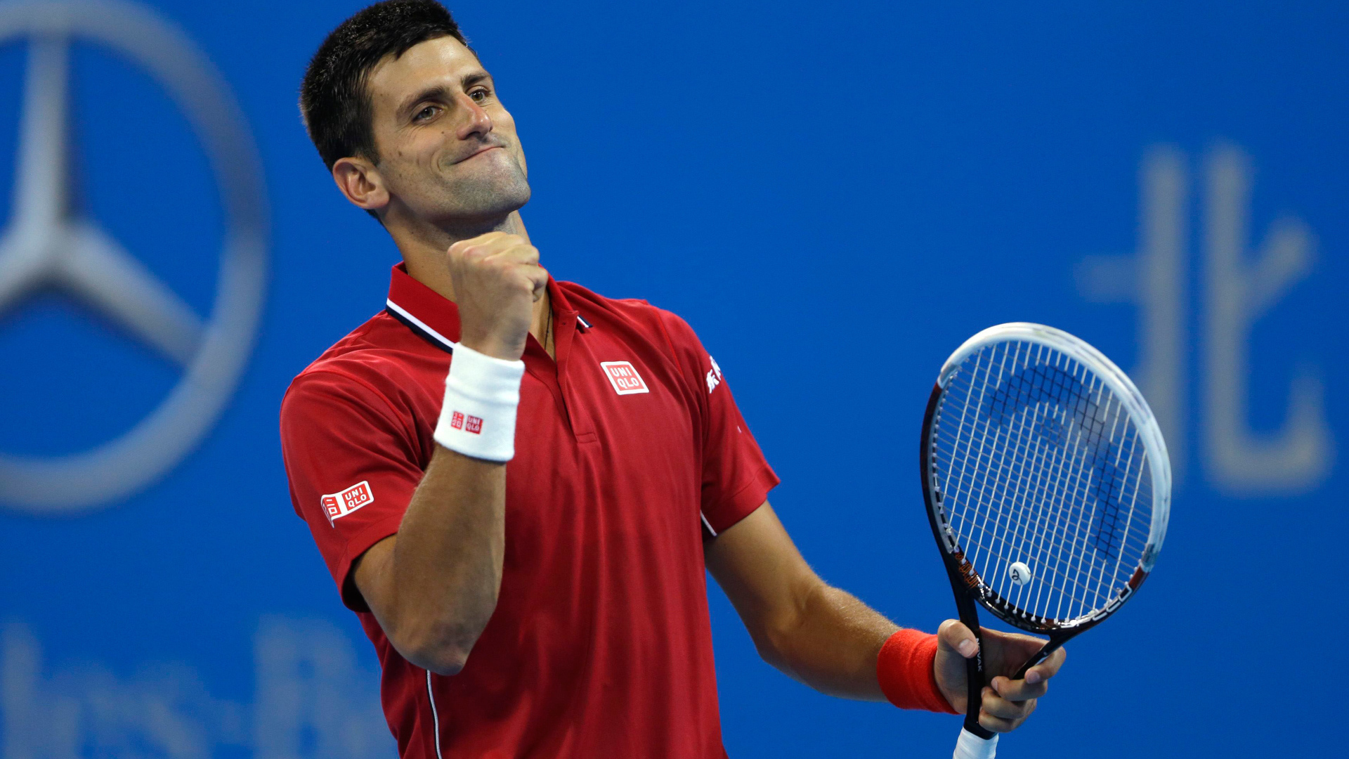 Теннисист Новак Джокович с ракеткой радуется на корте