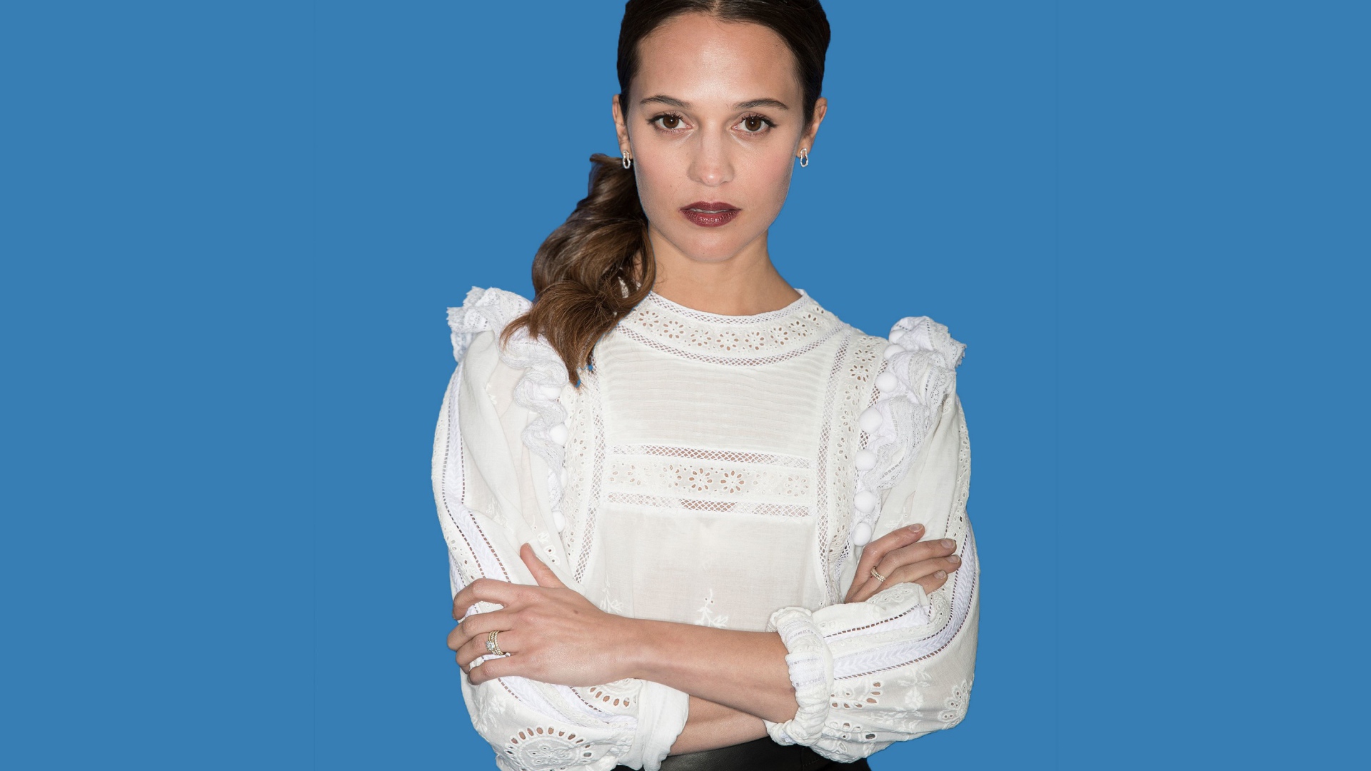 Актриса Алисия Викандер в белой блузке на синем фоне