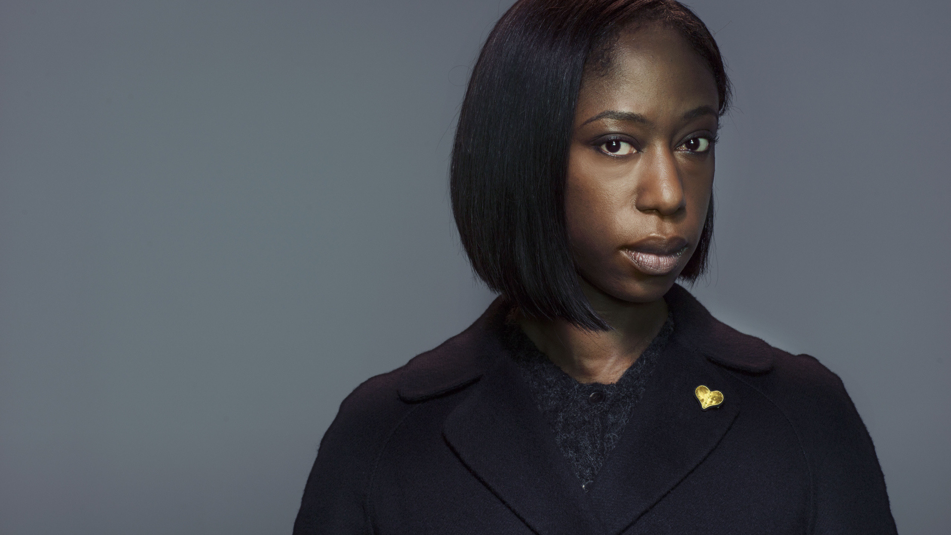 Актриса Никки Амука-Бёрд на сером фоне