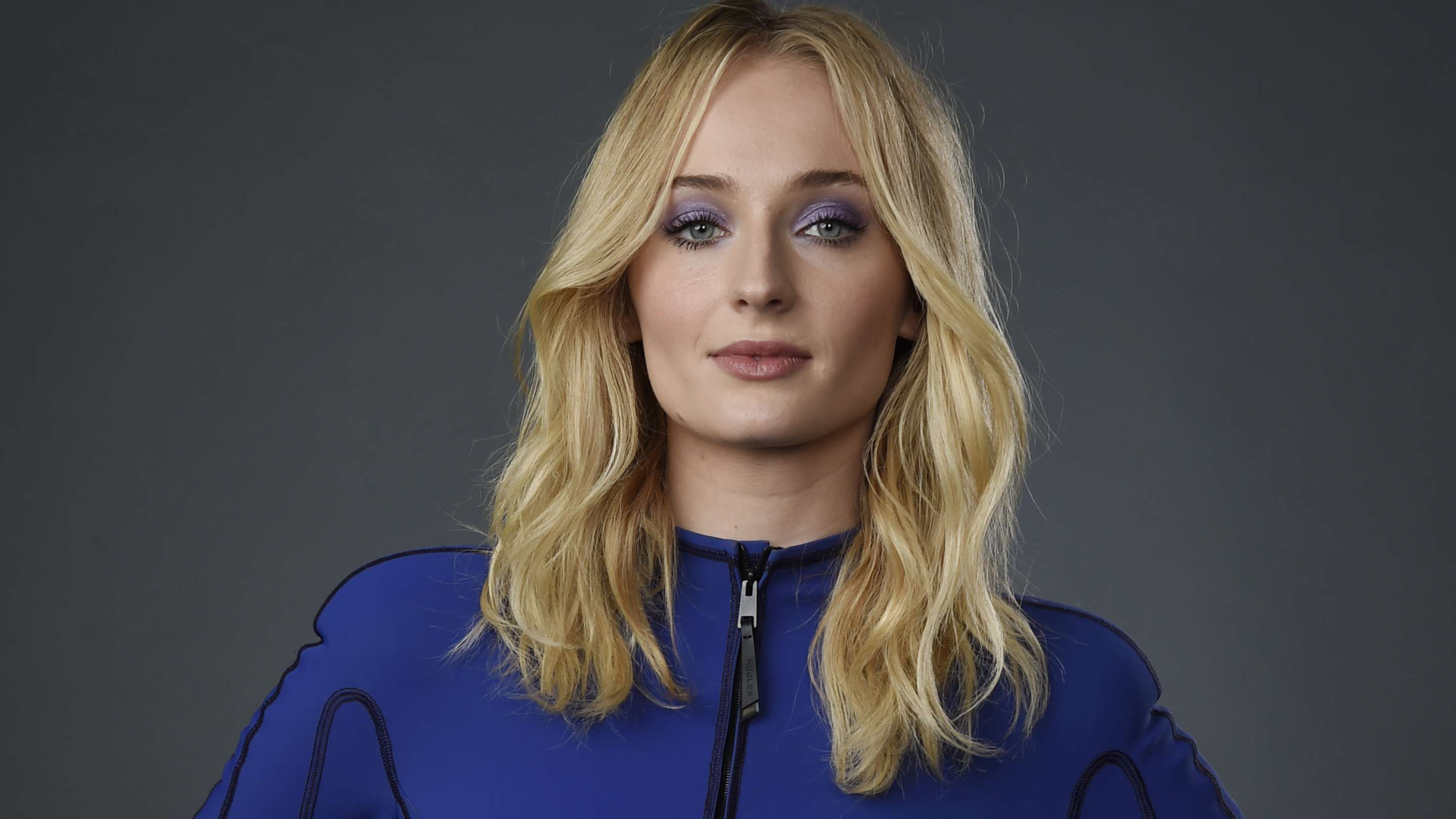 Актриса Софи Тернер крупным планом на сером фоне