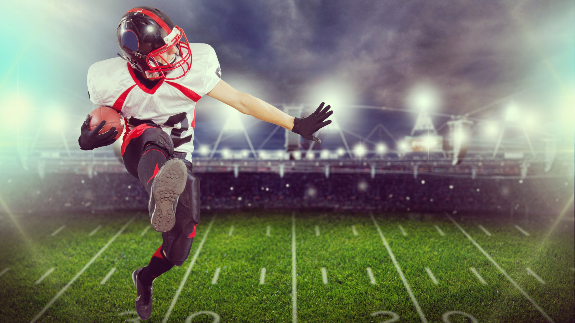 Игрок в американский футбол с мячом на поле