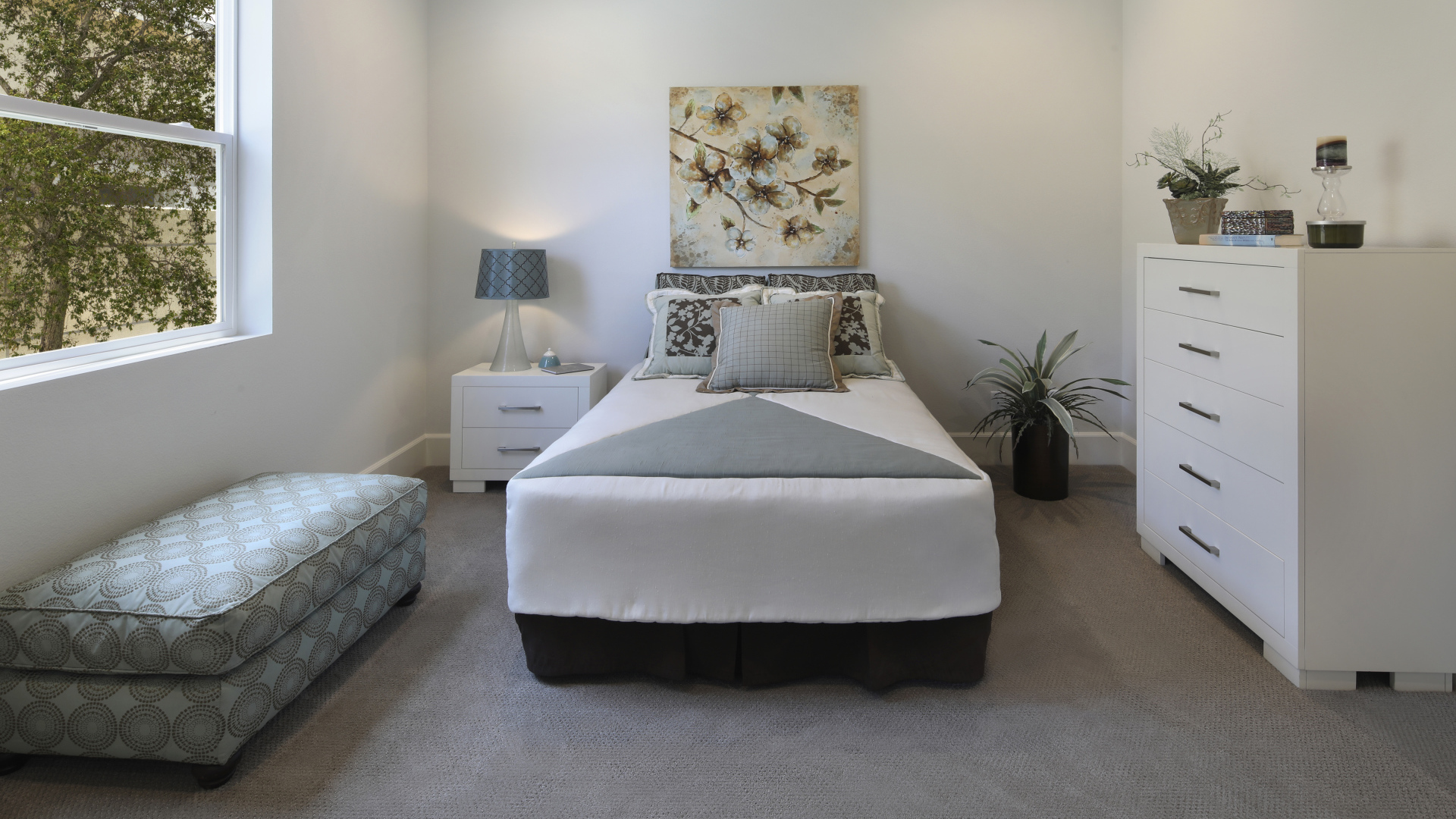 Спальная комната с кроватью и мягкой лежанкой у окна 