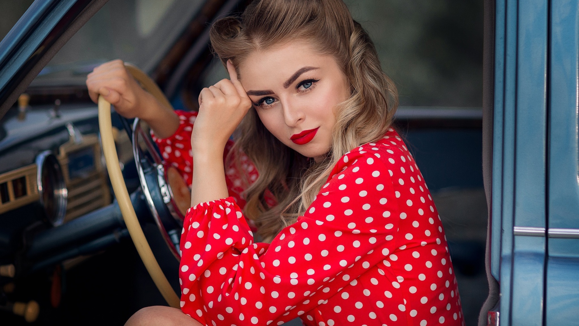 Голубоглазая ретро девушка за рулем автомобиля 