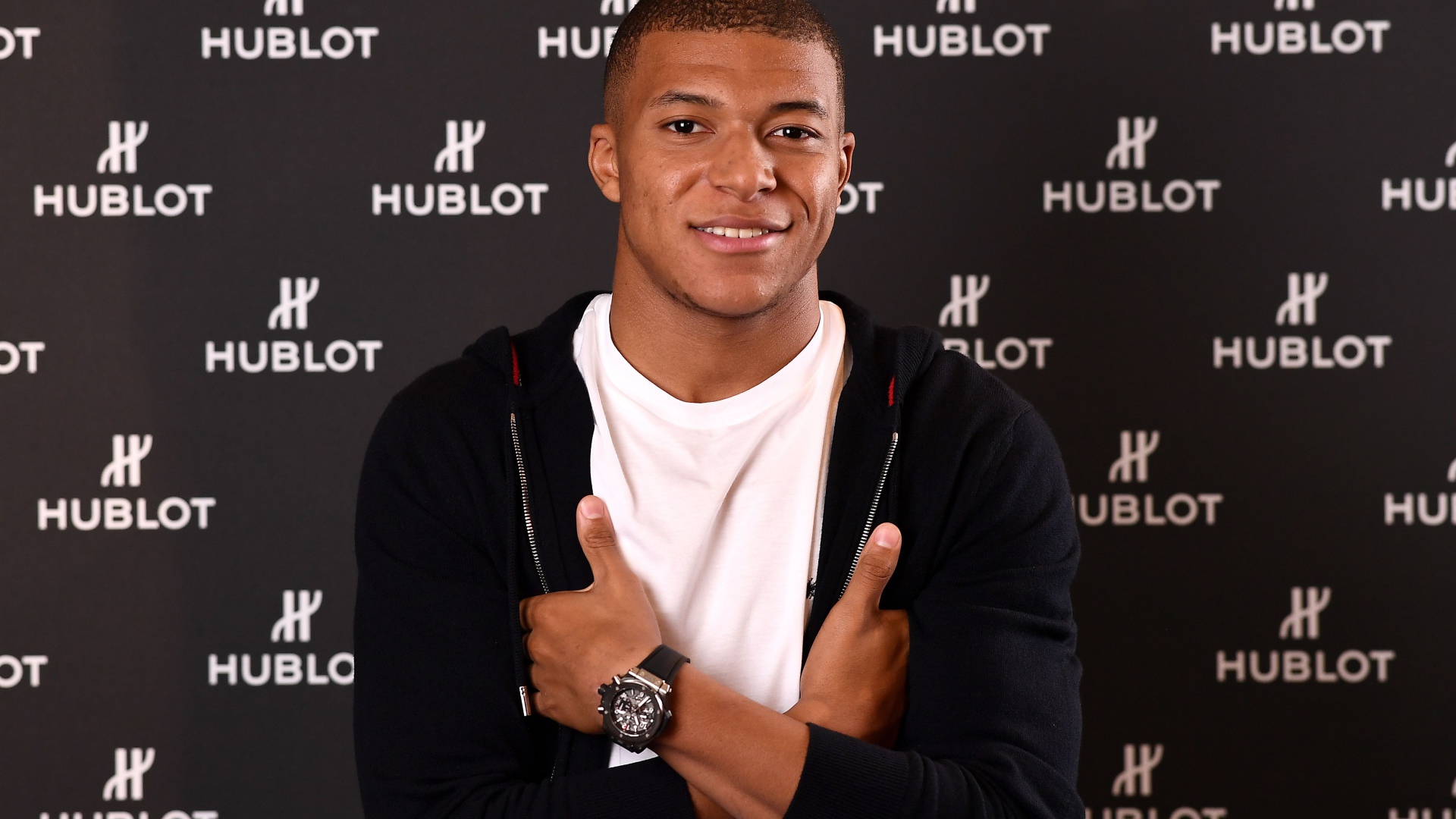 Футболист Килиан Мбаппе в костюме с часами на руке