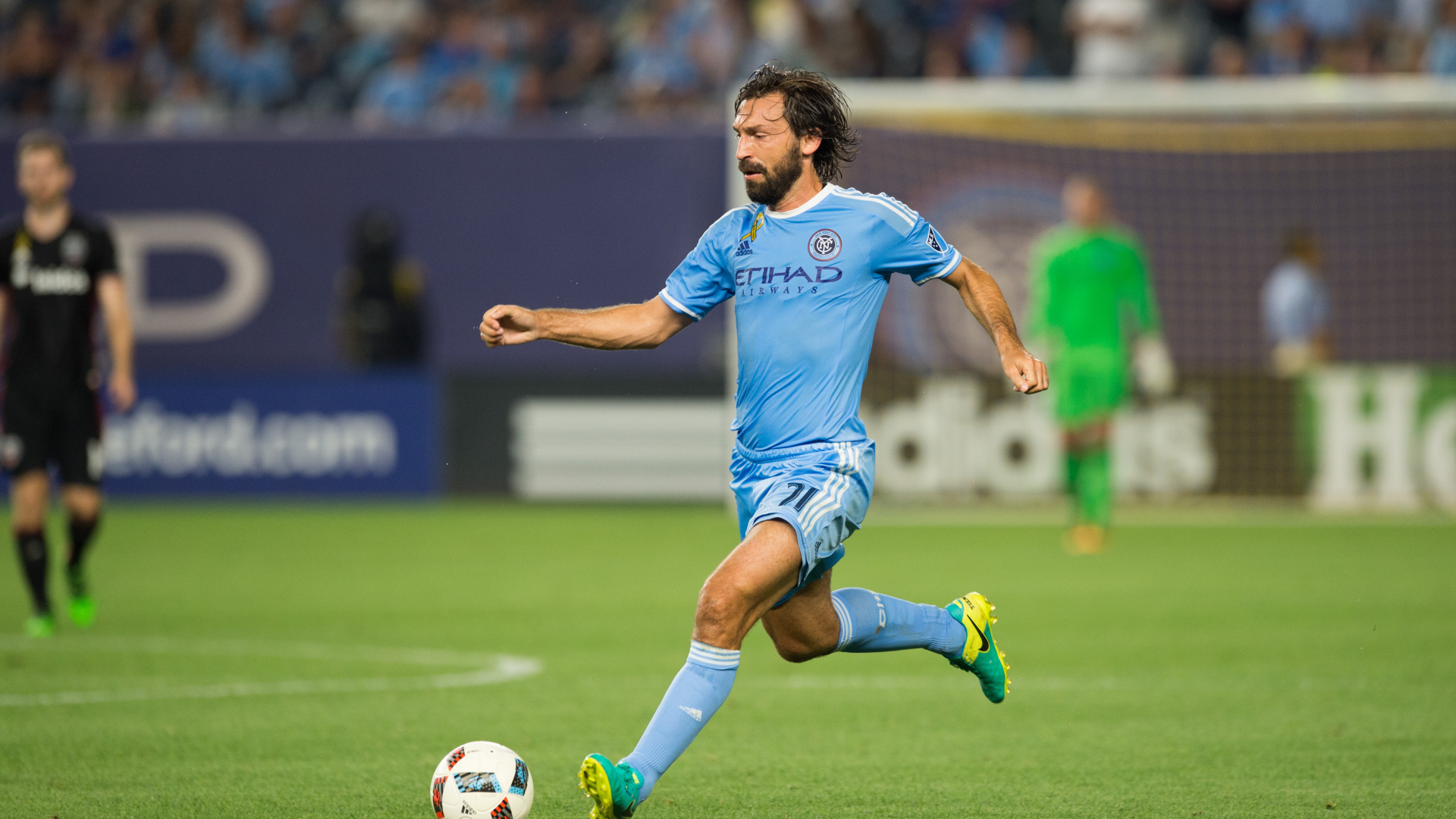 Итальянский футболист Андреа Пирло отбивает мяч на футбольном поле