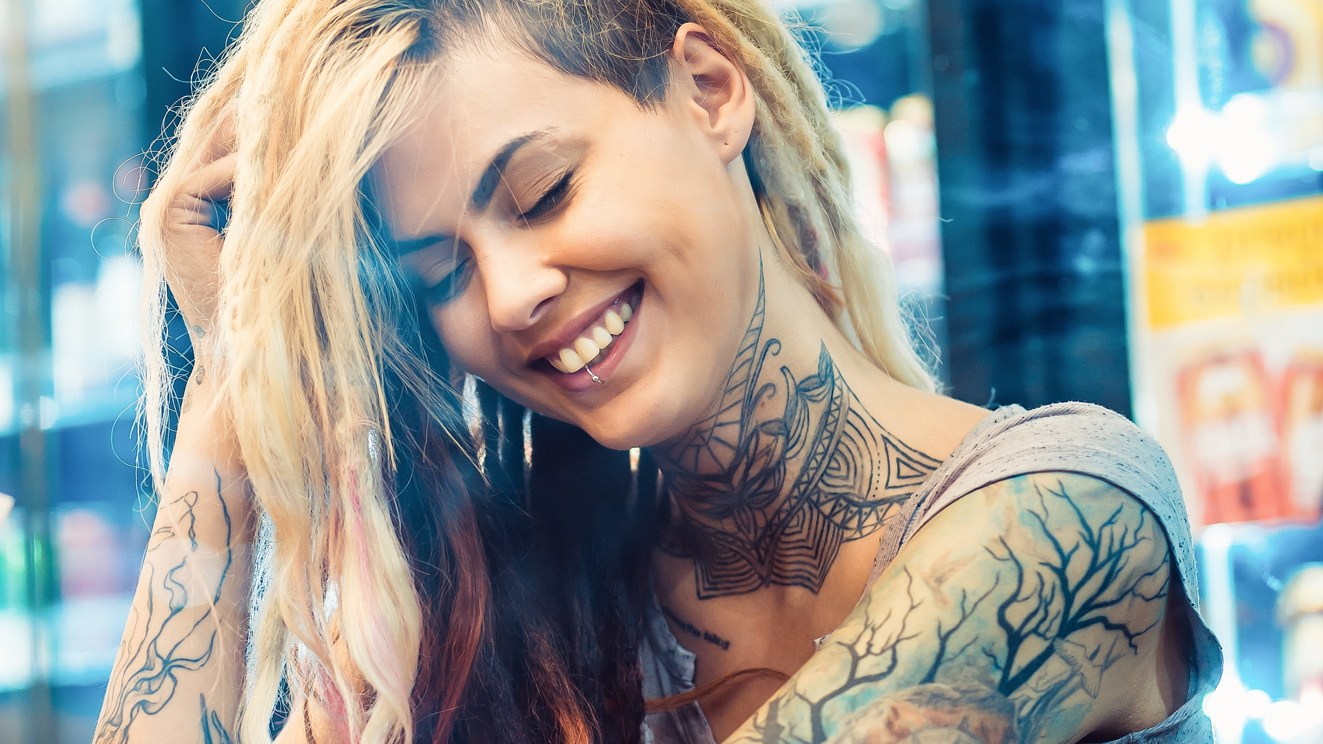 Улыбающаяся девушка с татуировками на теле