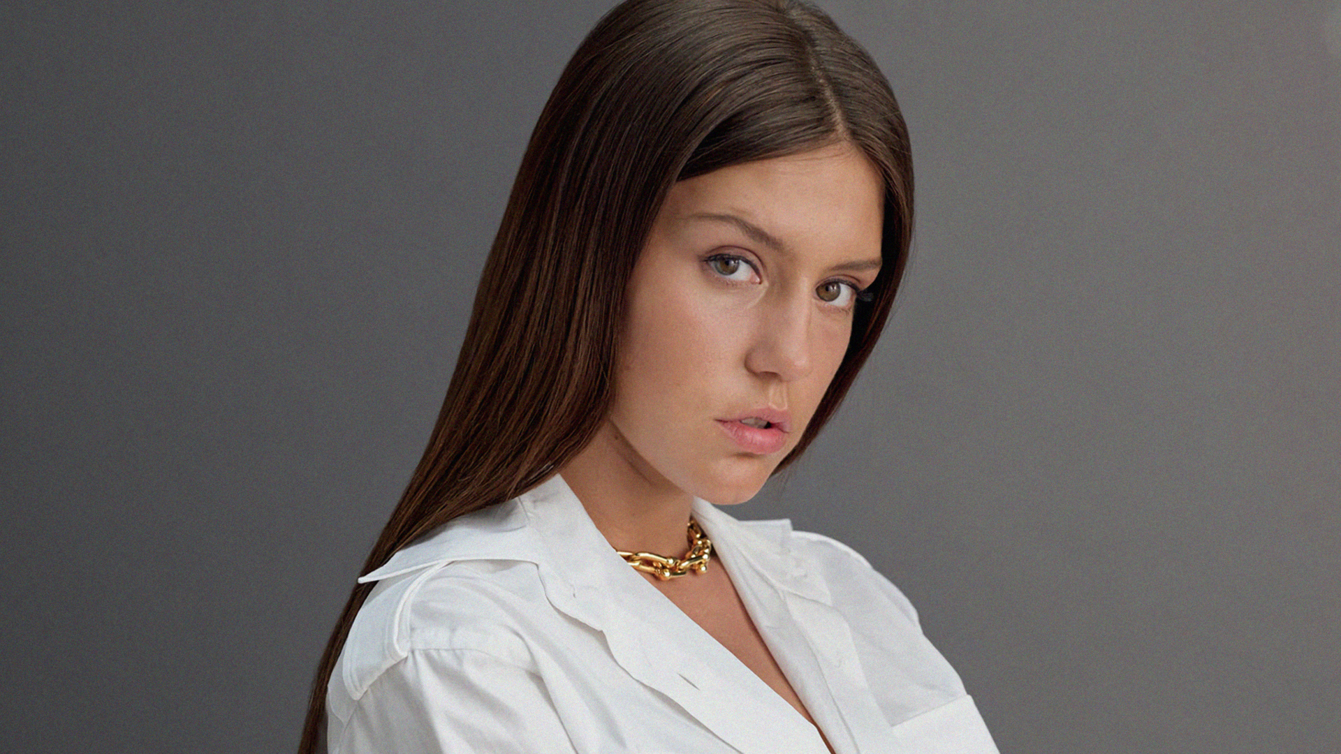 Молодая французская актриса Адель Экзаркопулос на сером фоне