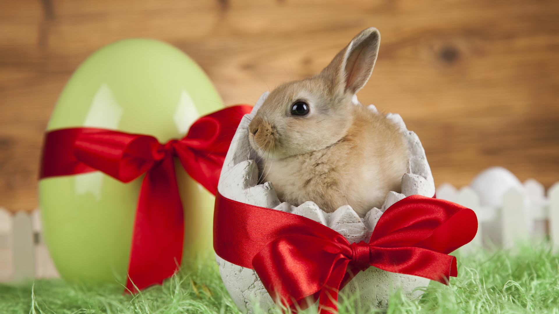 Little decorative rabbit in an egg with a red bow