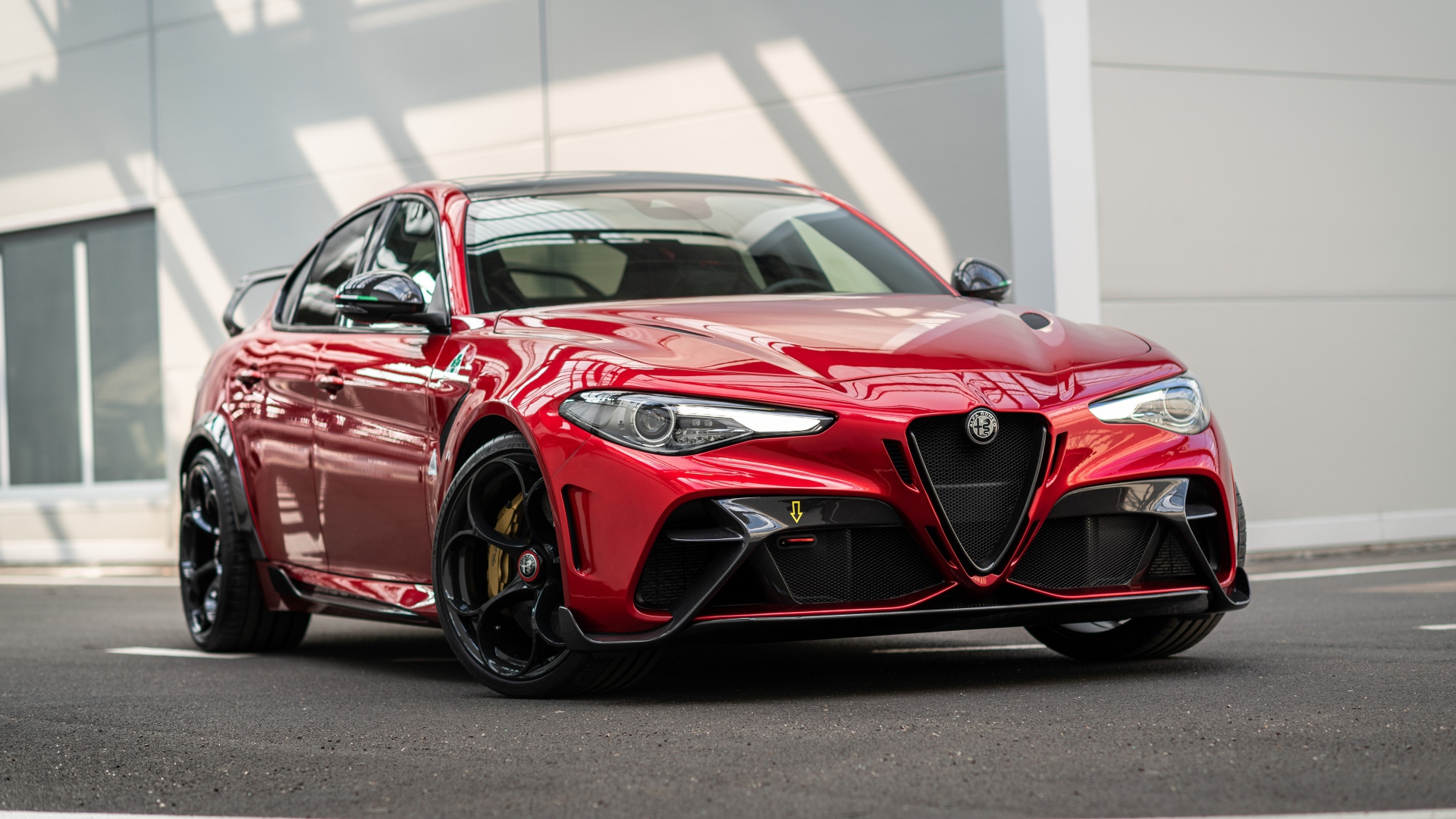 Красный автомобиль Alfa Romeo Giulia GTAm 2020 года у гаража