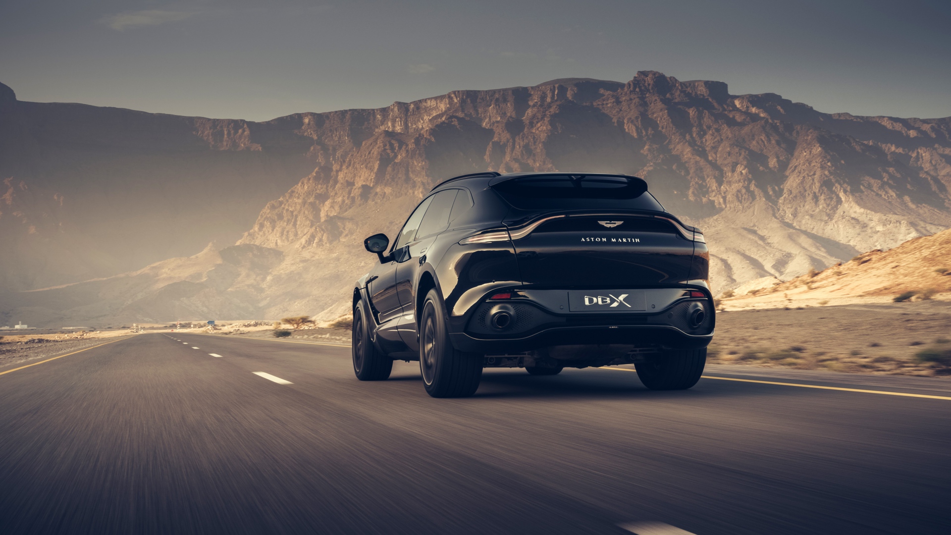 Черный внедорожник Aston Martin DBX 2020 года в горах 