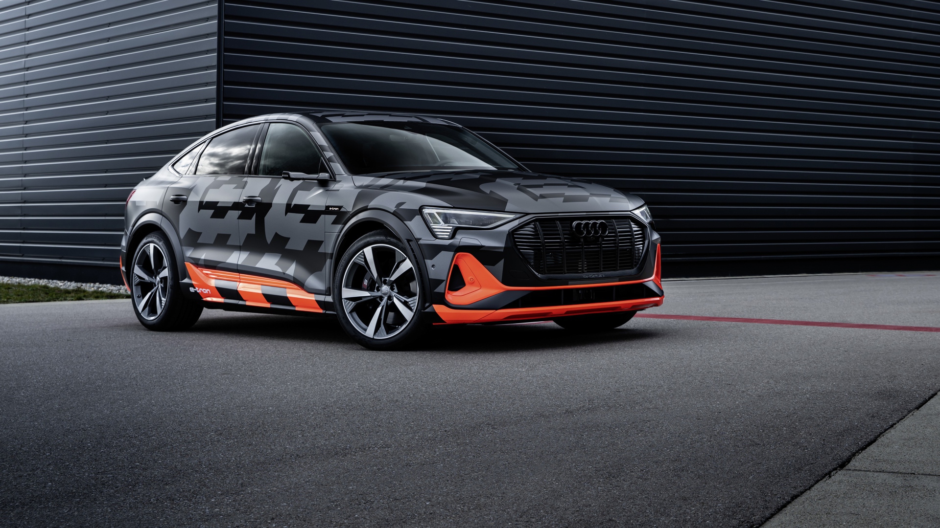 Автомобиль Audi E-Tron S Sportback Prototype 2020 года на фоне черной стены 