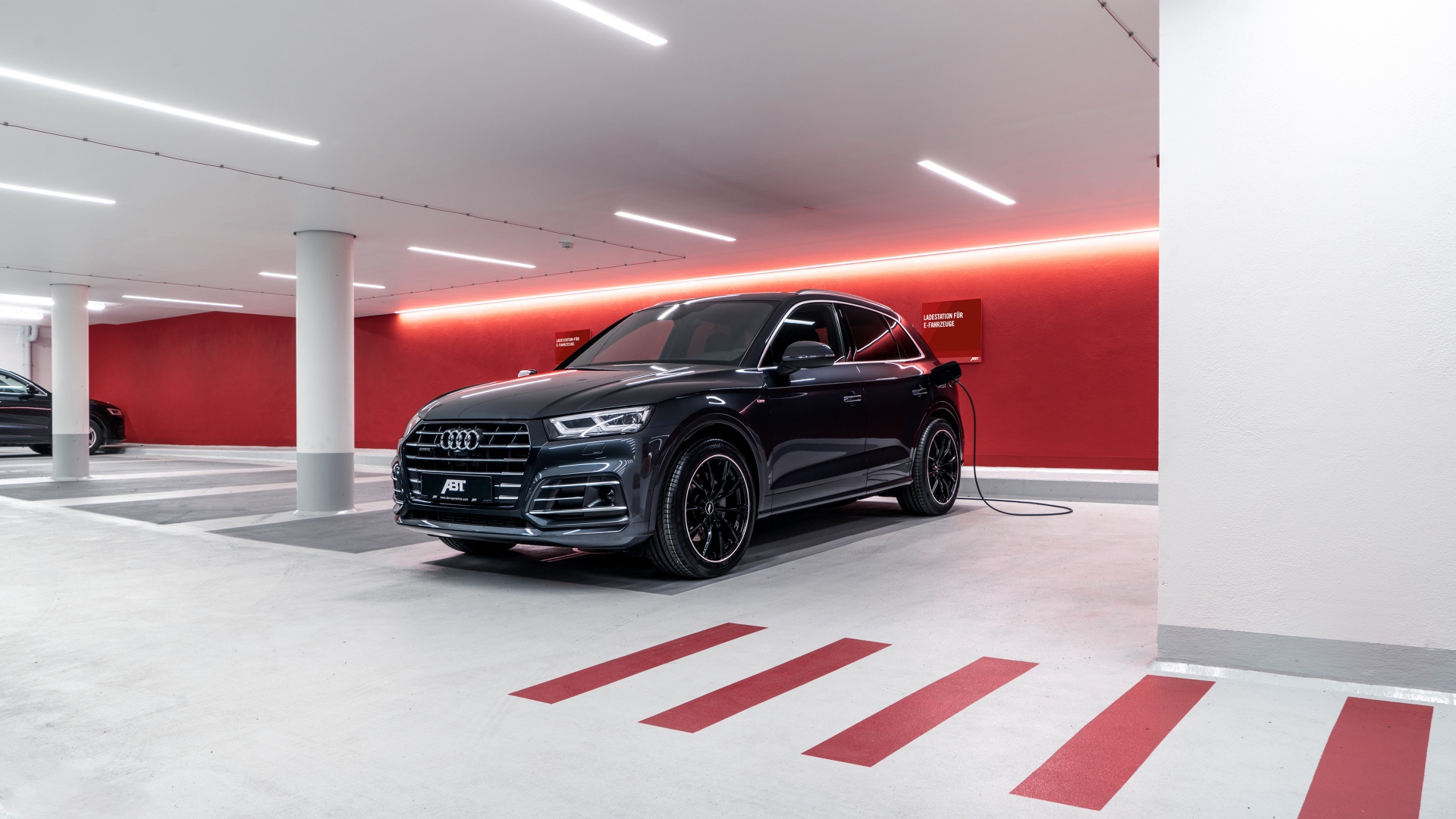 Черный автомобиль ABT Audi Q5 55 TFSI E 2020 года на заправке 