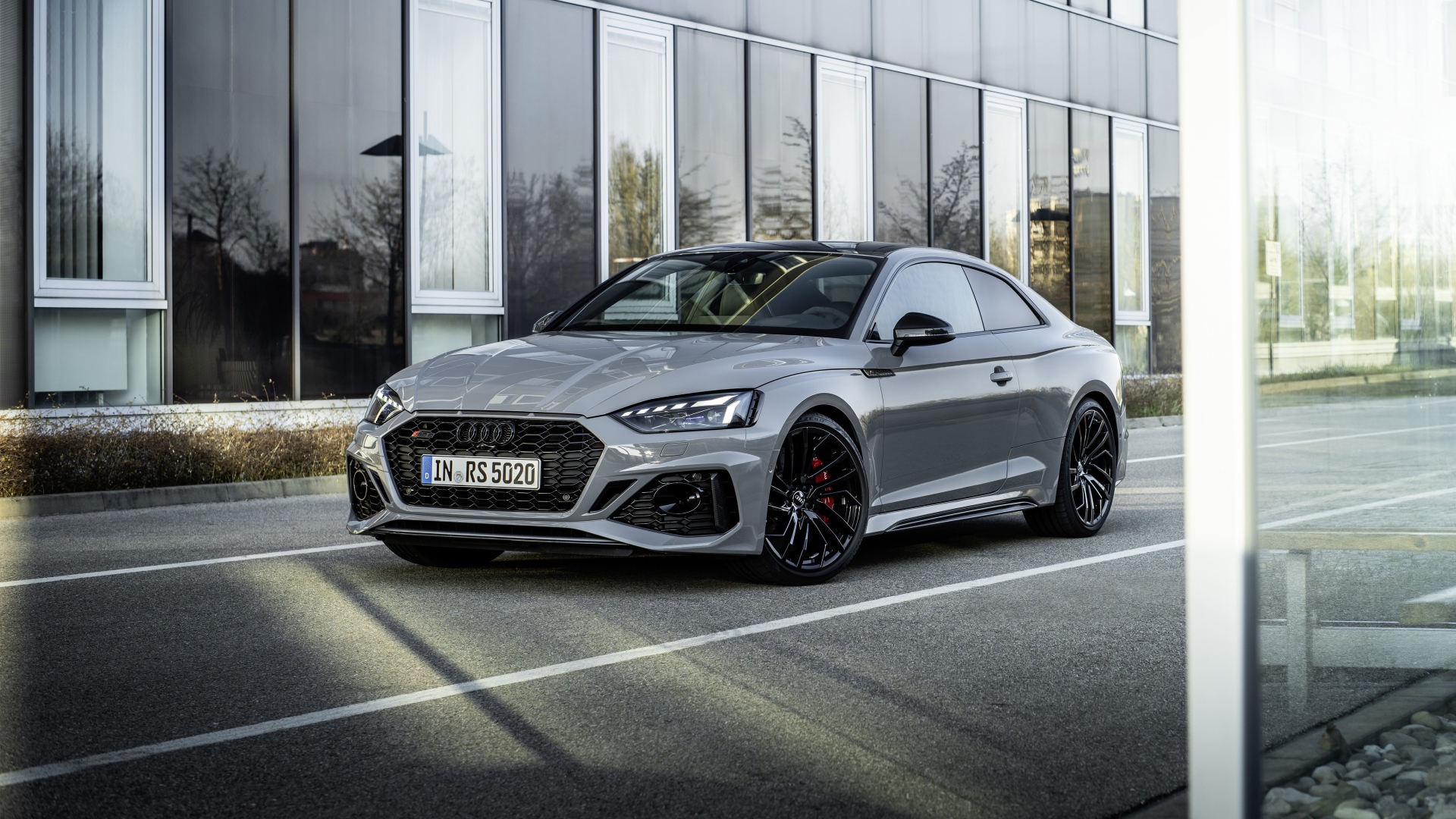 Серебристый автомобиль Audi RS 5 Coupe у здания 