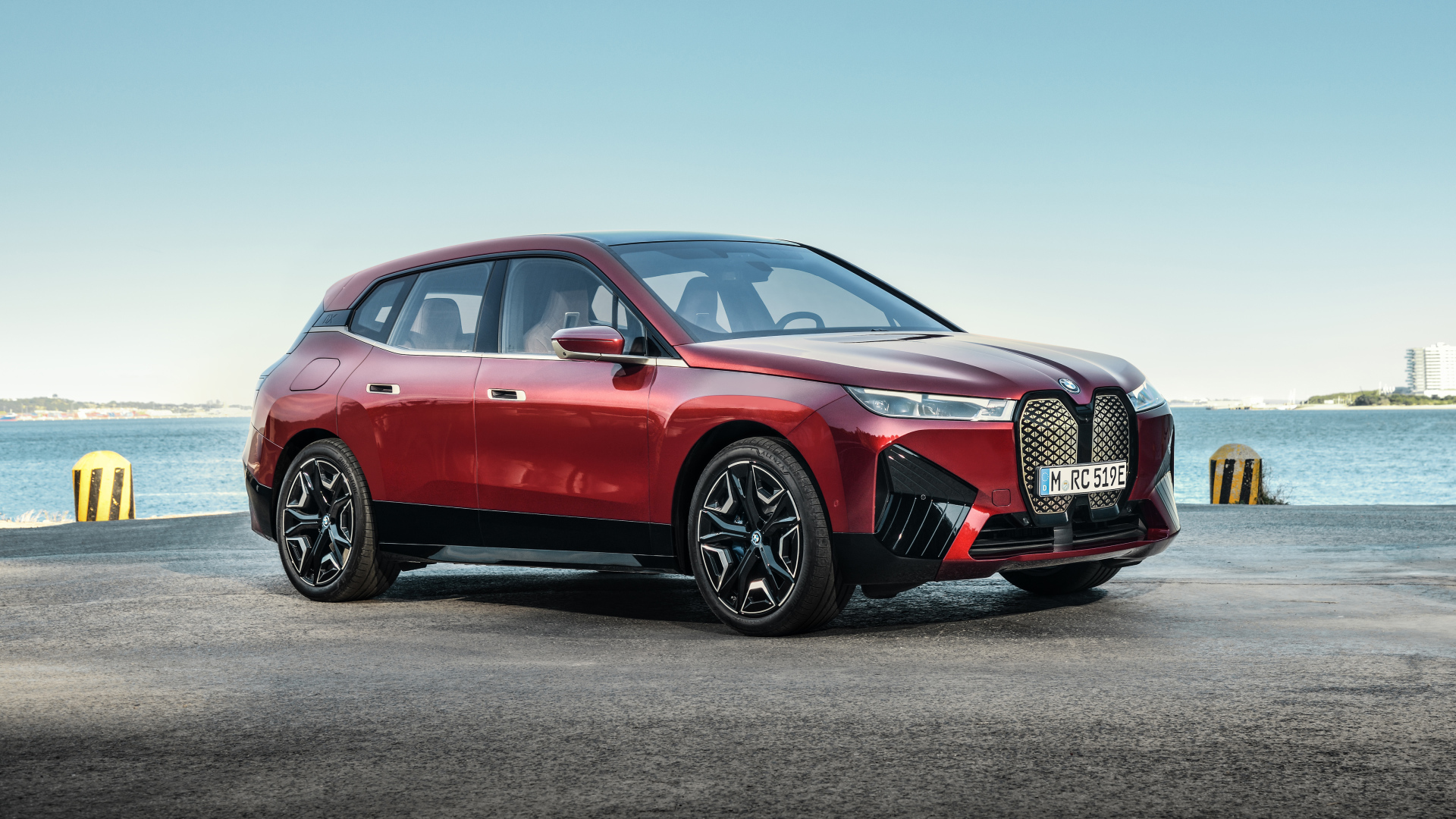 Бордовый автомобиль BMW IX 2021 года у воды