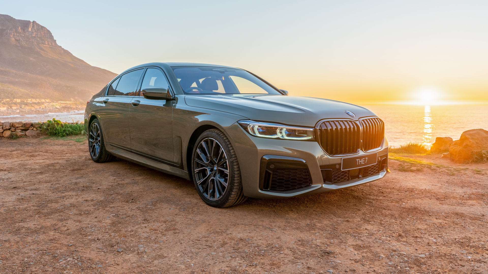 Стильный дорогой автомобиль BMW 745Le , 2020 года на фоне заката
