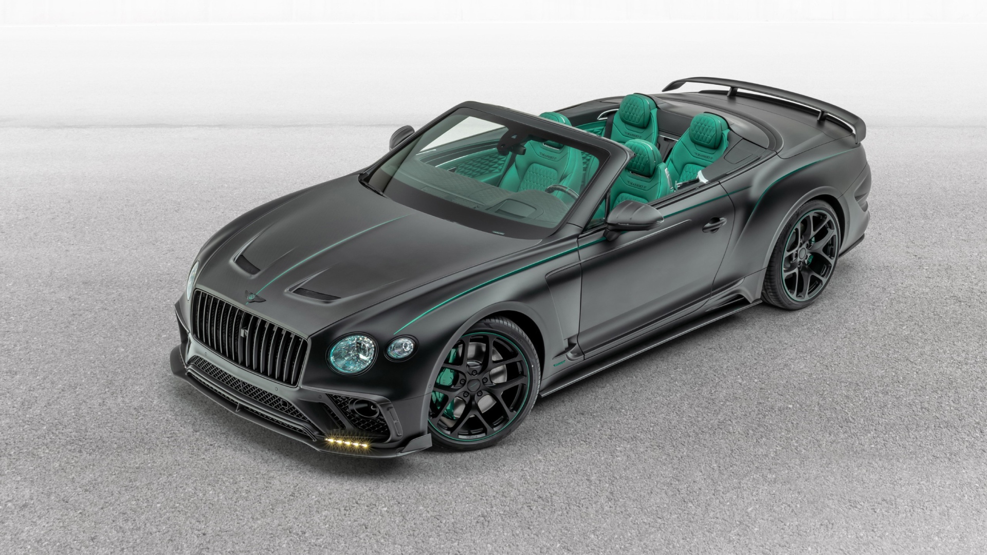 Черный автомобиль Mansory Bentley Continental GT V8 Convertible 2020 года на сером фоне