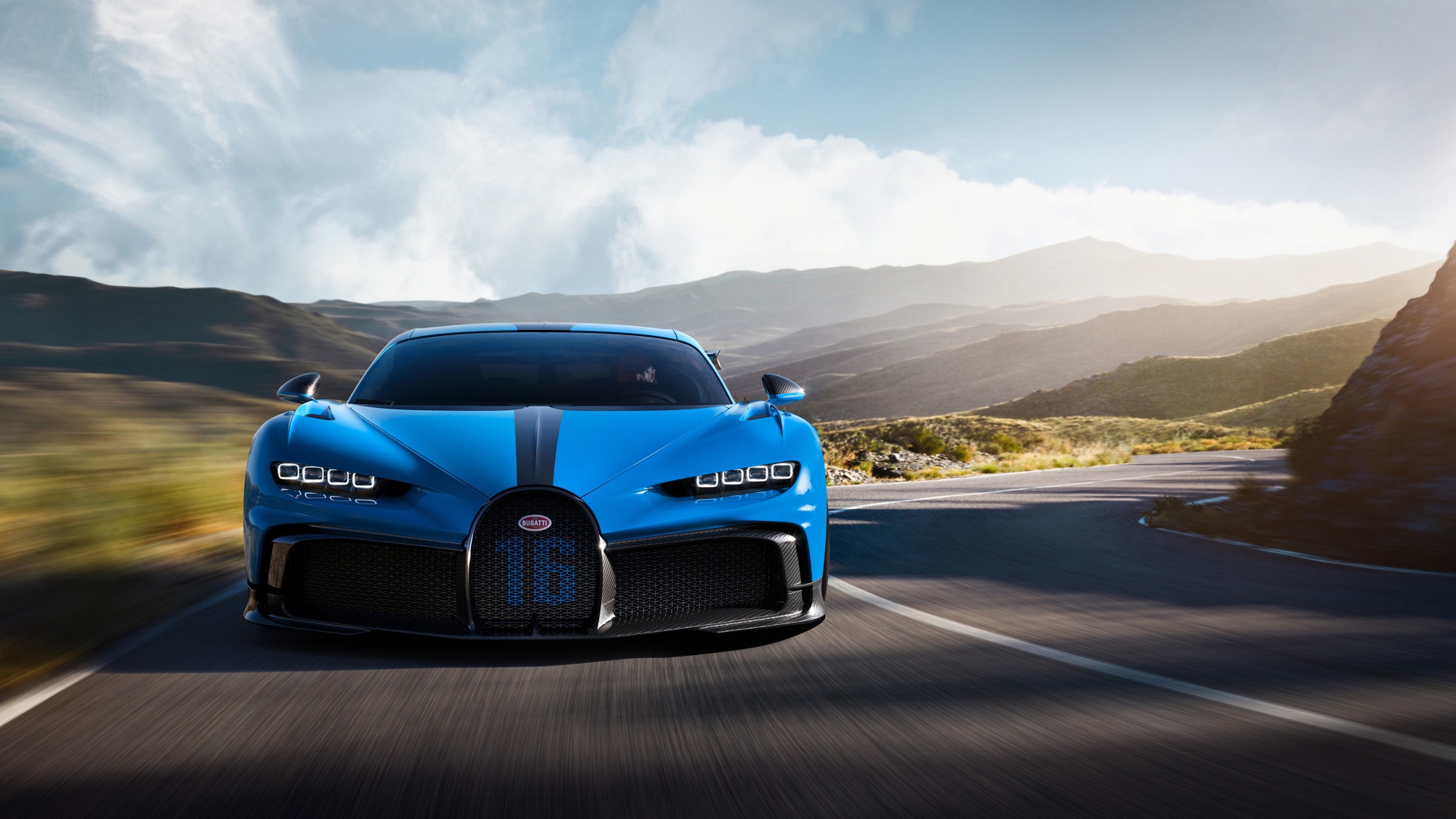 Синий автомобиль Bugatti Chiron Pur Sport 2020 года на трассе в горах 