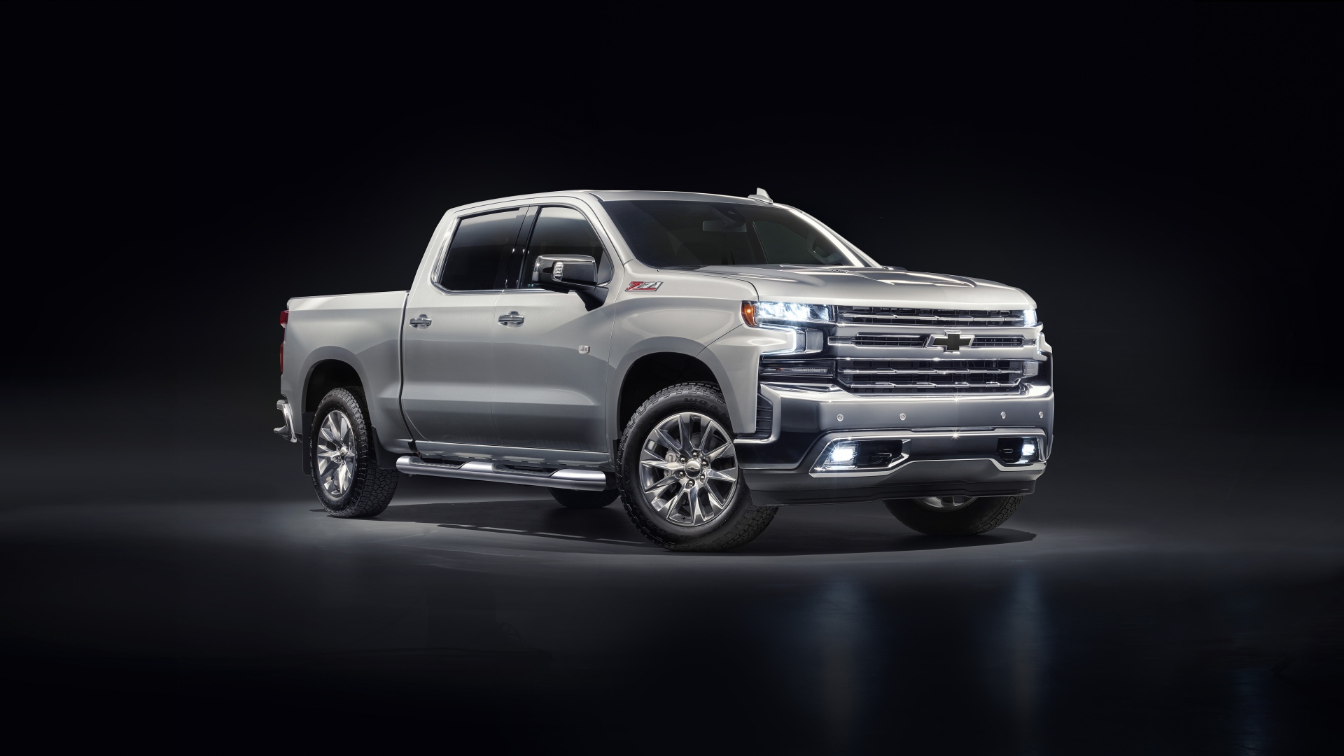 Серебристый автомобиль Chevrolet Silverado 1500 LTZ Z71 Premium Edition 2020 года на черном фоне