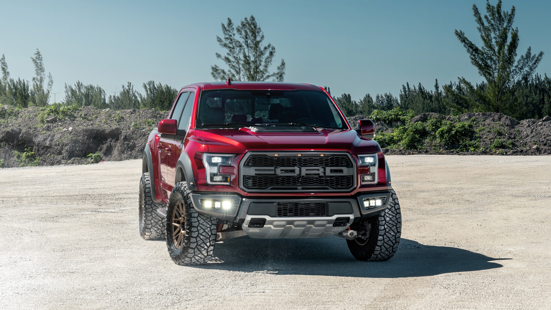 Красный внедорожник Ford F-150 Raptor на песке