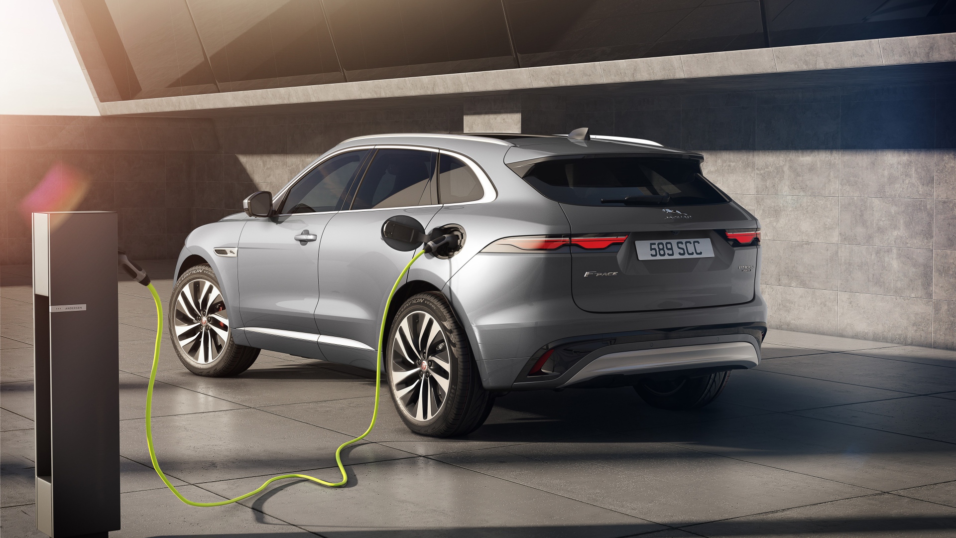 Серебристый автомобиль Jaguar F-Pace P400e AWD 2020 года на заправке 