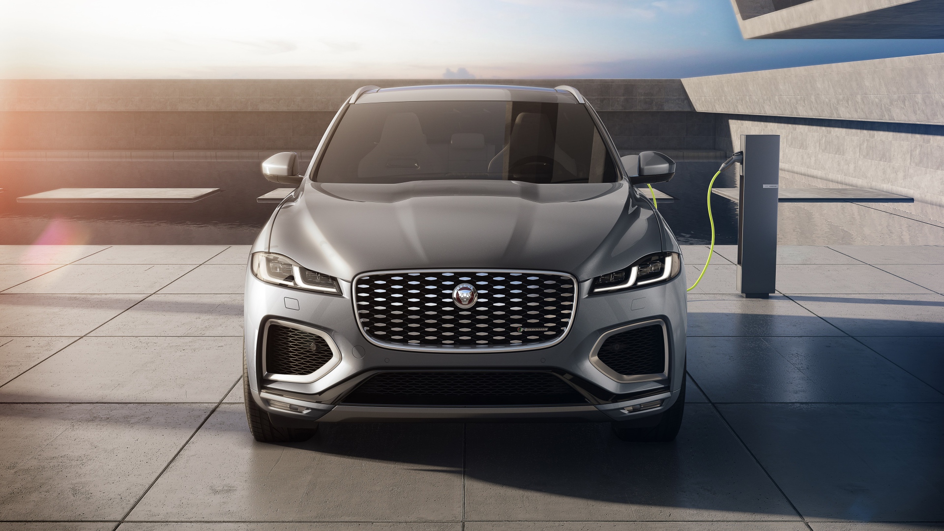 Серый автомобиль Jaguar F-Pace P400e AWD 2020 года на заправке