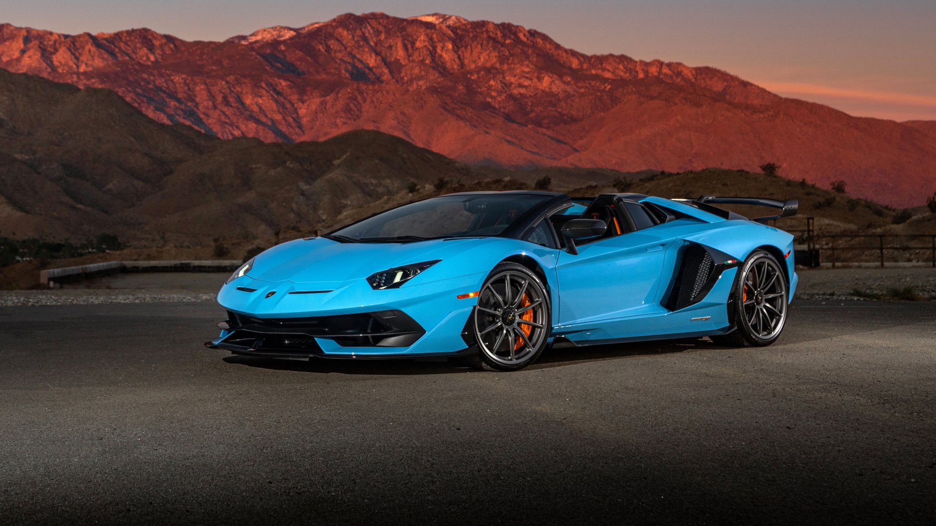 Голубой спортивный автомобиль Lamborghini Aventador SVJ Roadster, 2020 года на фоне гор