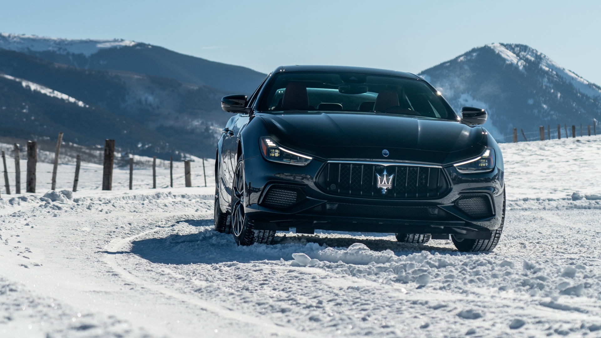Черный автомобиль Maserati Ghibli S Q4, 2020 года едет по заснеженной дороге