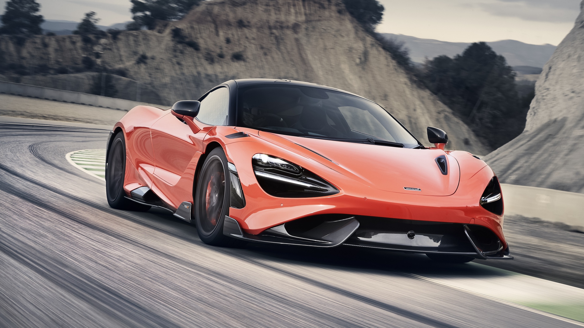 Красный автомобиль McLaren 765LT 2020 года на дороге в горах 
