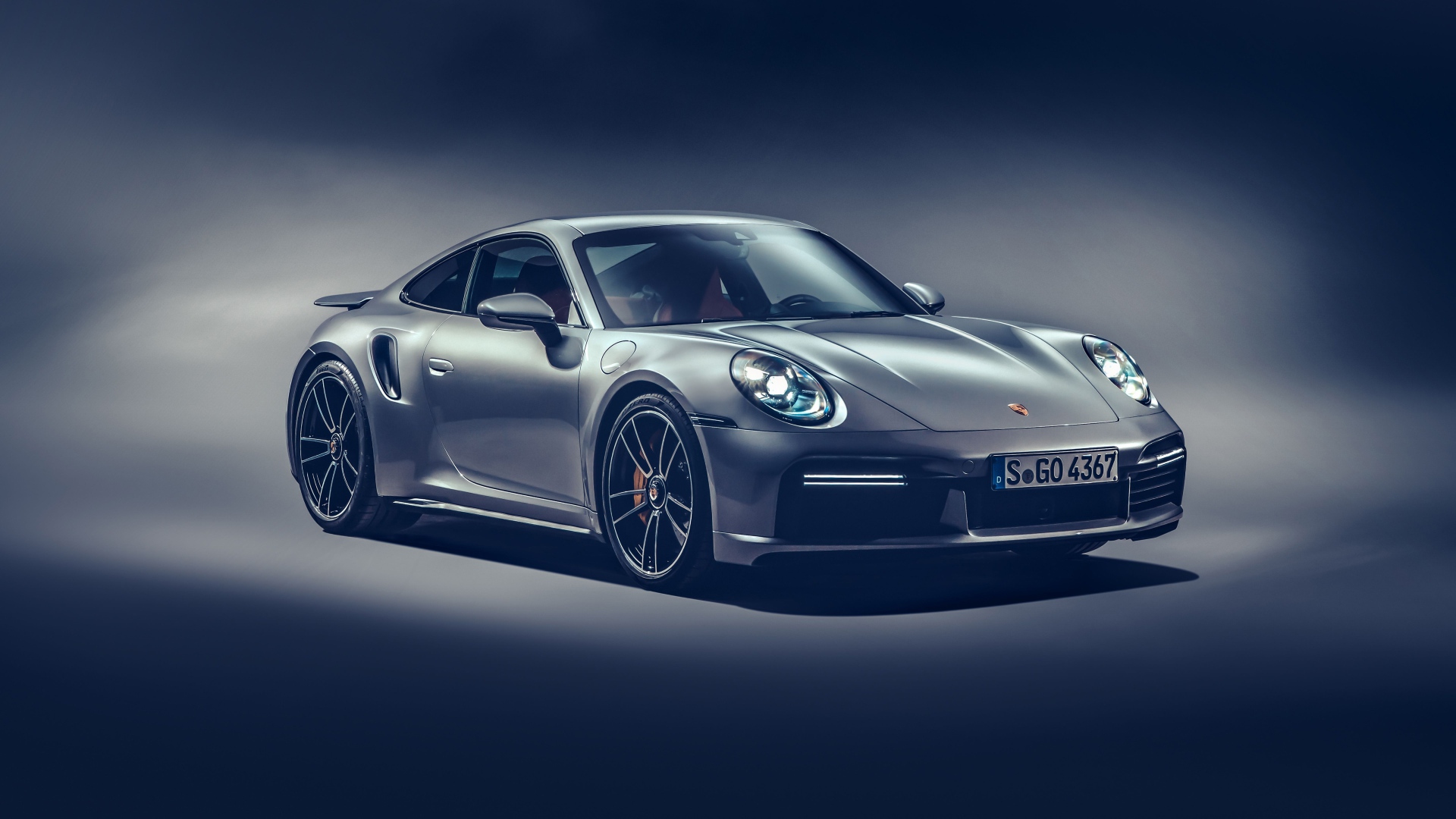 Автомобиль Porsche 911 Turbo S 2020 года на сером фоне