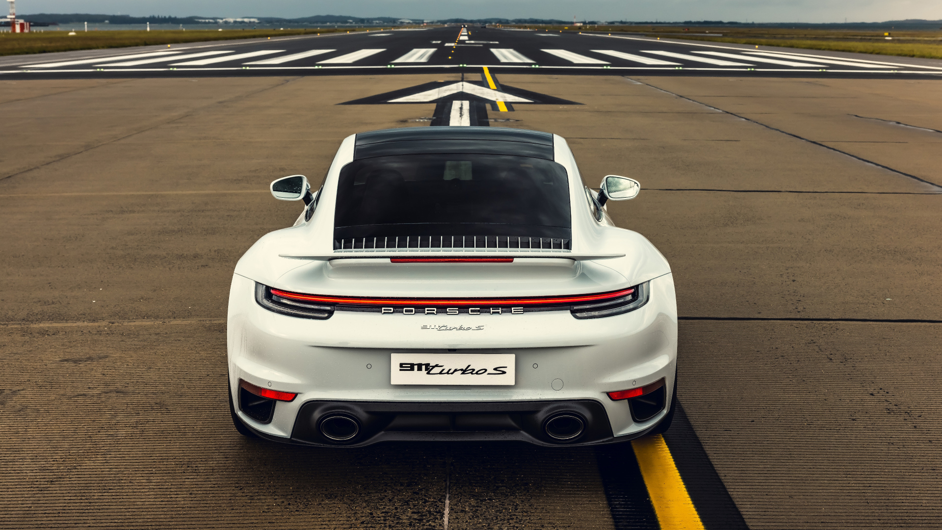 Белый автомобиль  Porsche 911 Turbo S 2020 года вид сзади