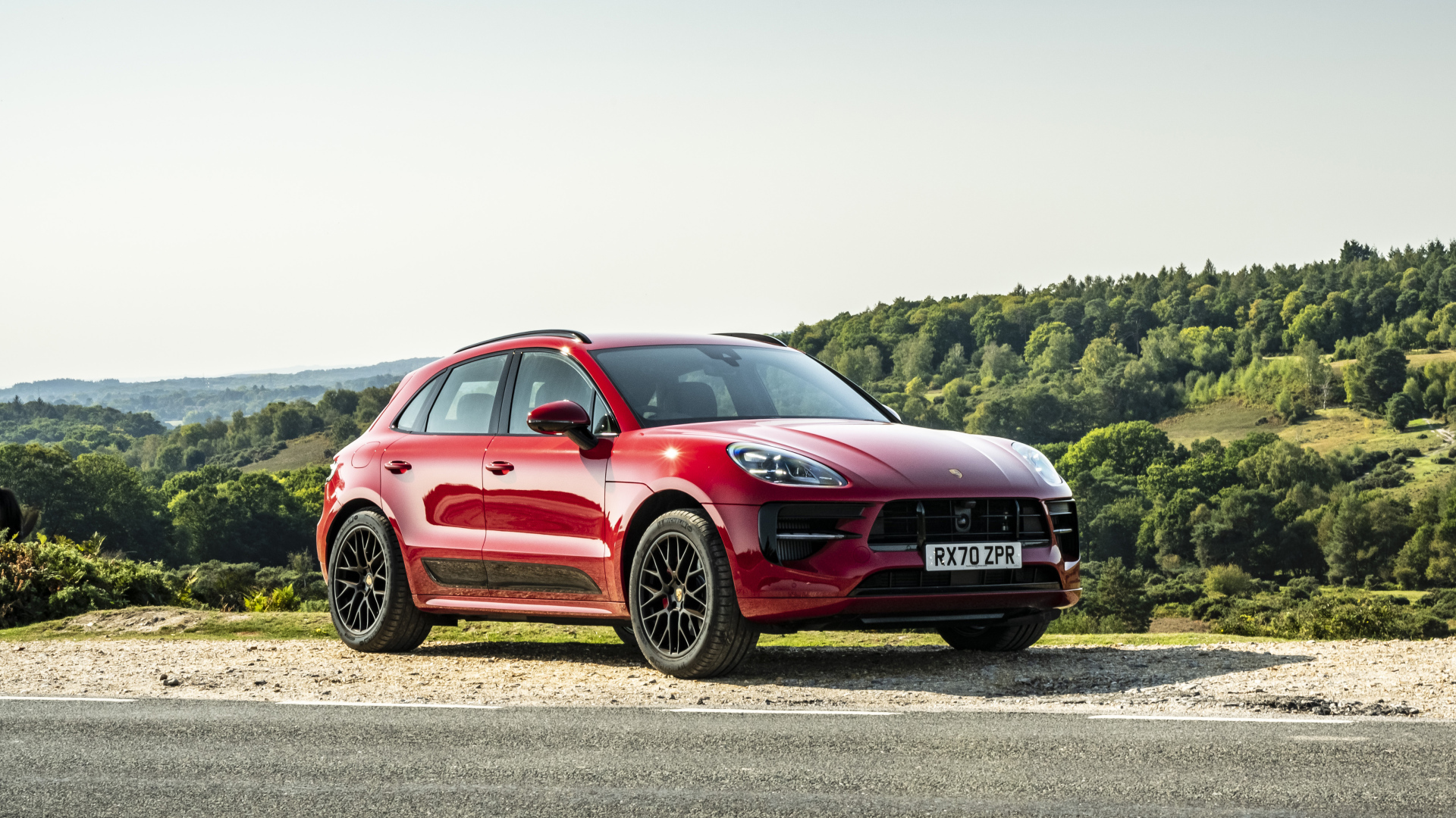 Красный автомобиль Porsche Macan GTS 2020  года в лучах солнца