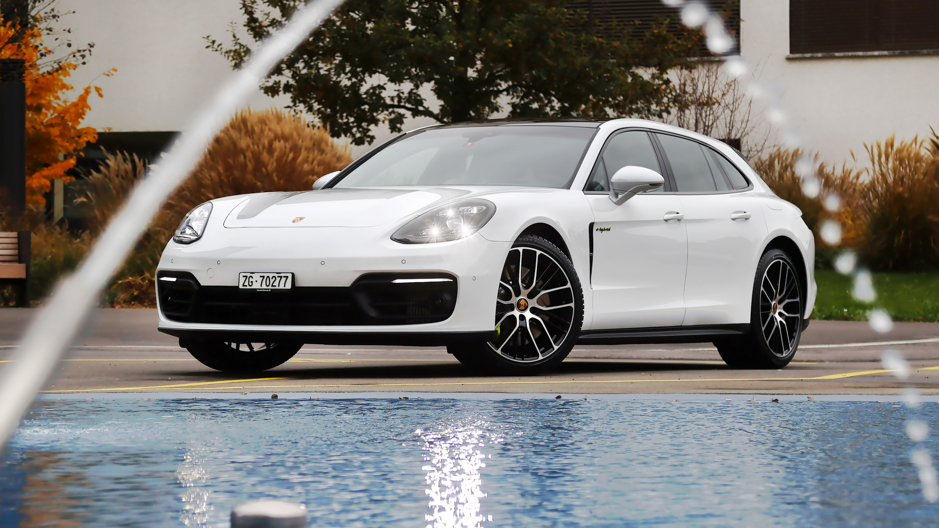 Белый автомобиль Porsche Panamera 4S E-Hybrid Sport Turismo 2020 года у бассейна