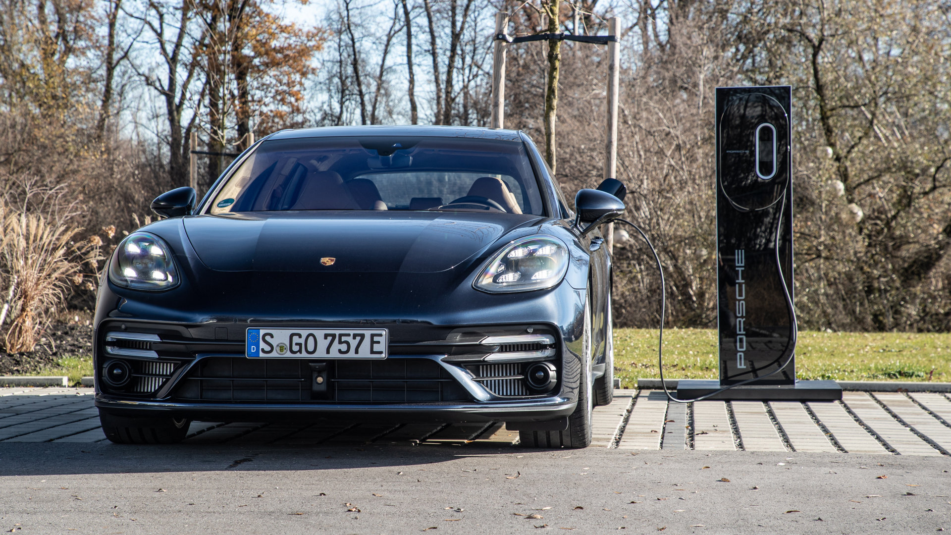 Черный автомобиль Porsche Panamera Turbo S E-Hybrid Sport Turismo 2021 года на заправке