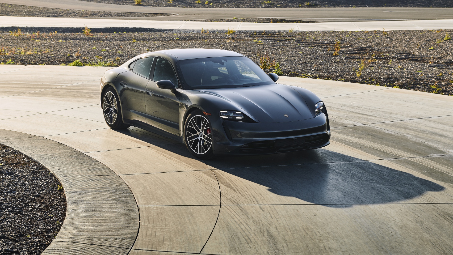 Черный автомобиль Porsche Taycan, 2020 года на дороге 