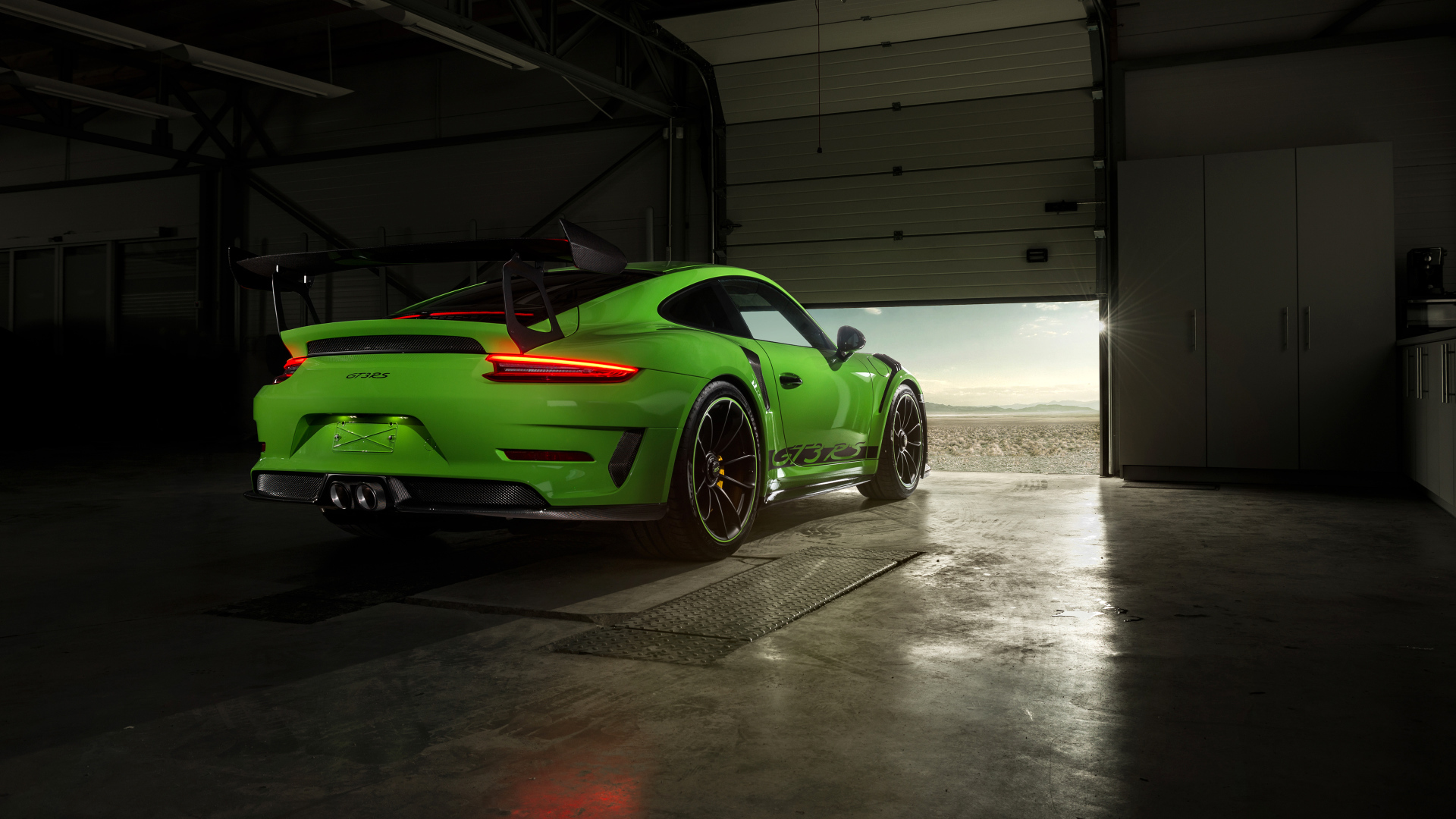 Зеленый автомобиль Porsche GT3 RS вид сзади