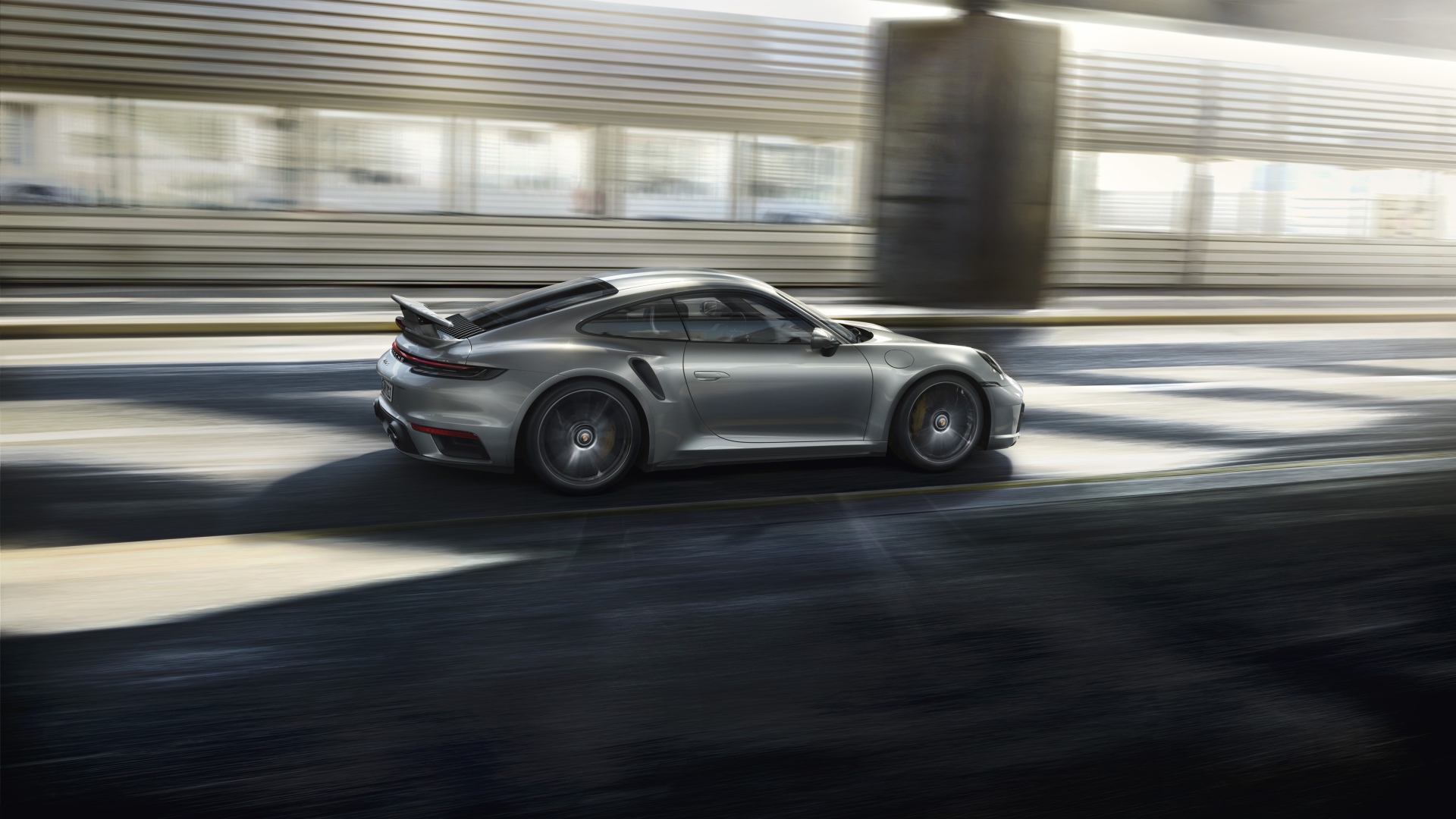 Серебристый автомобиль Porsche 911 Turbo S 2020 года на трассе 