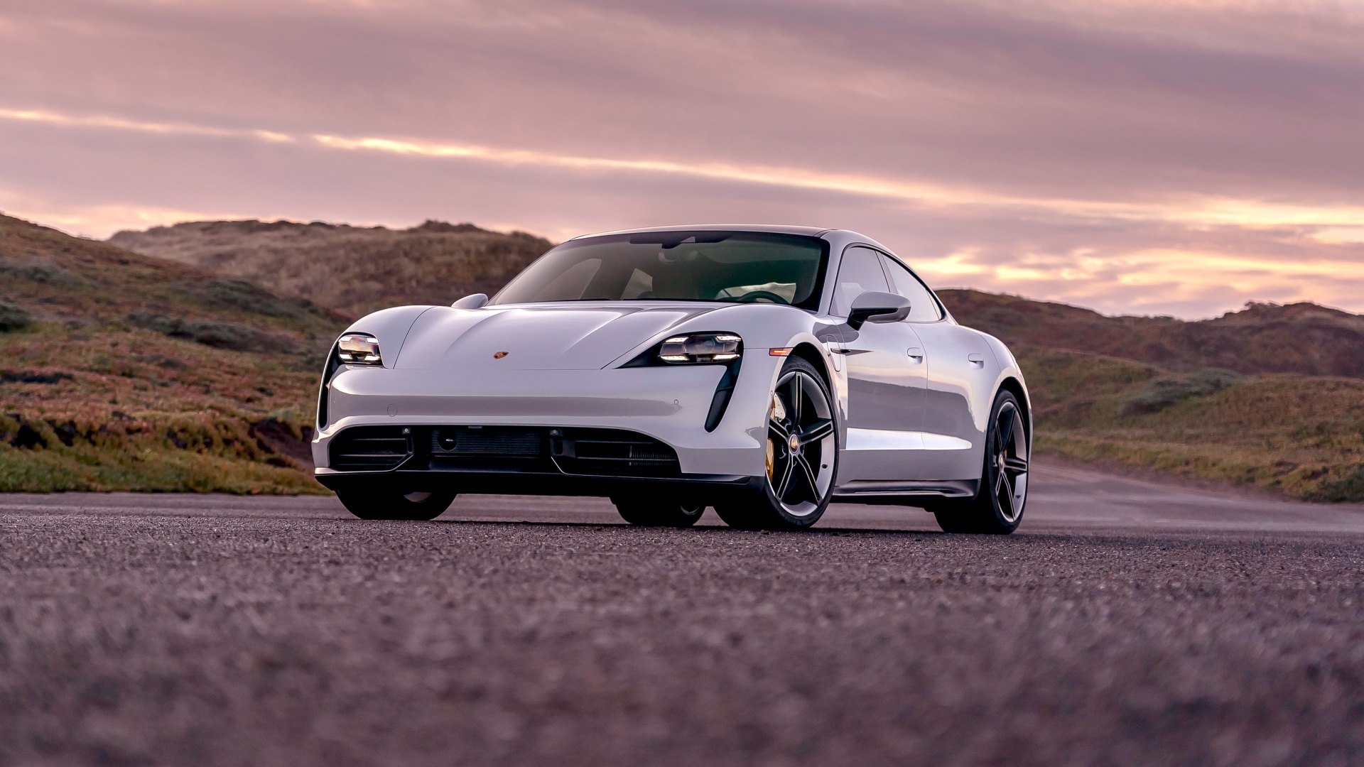 Серебристый автомобиль Porsche Taycan Turbo S 2020 года на фоне неба