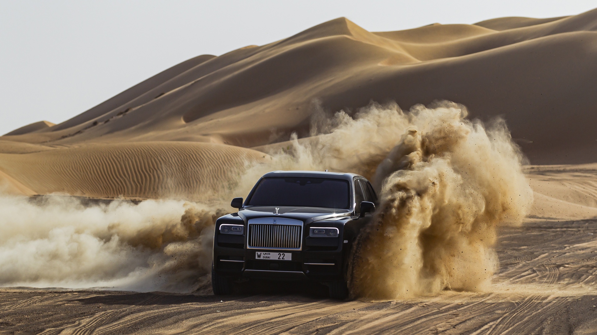 Черный автомобиль Rolls-Royce Cullinan в пустыне