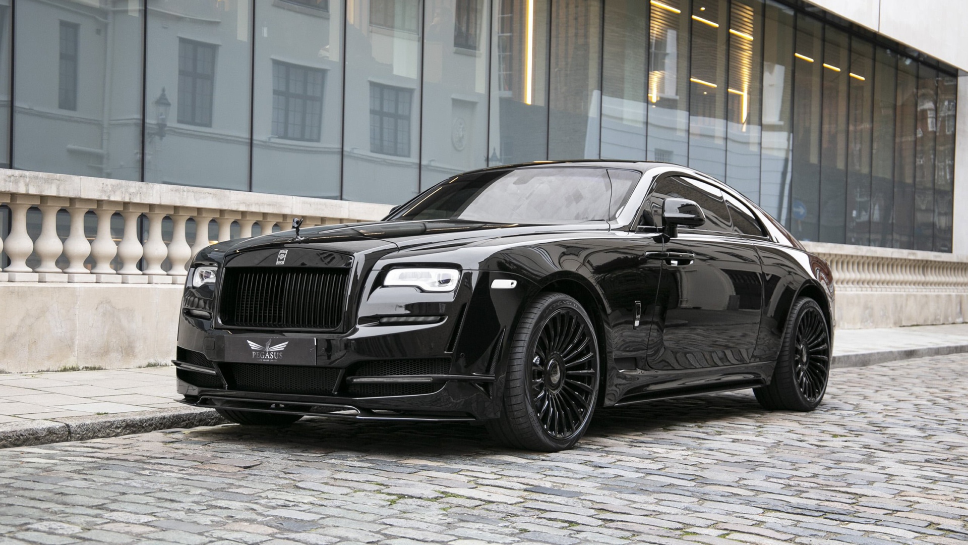 Черный автомобиль Rolls-Royce Wraith у здания 