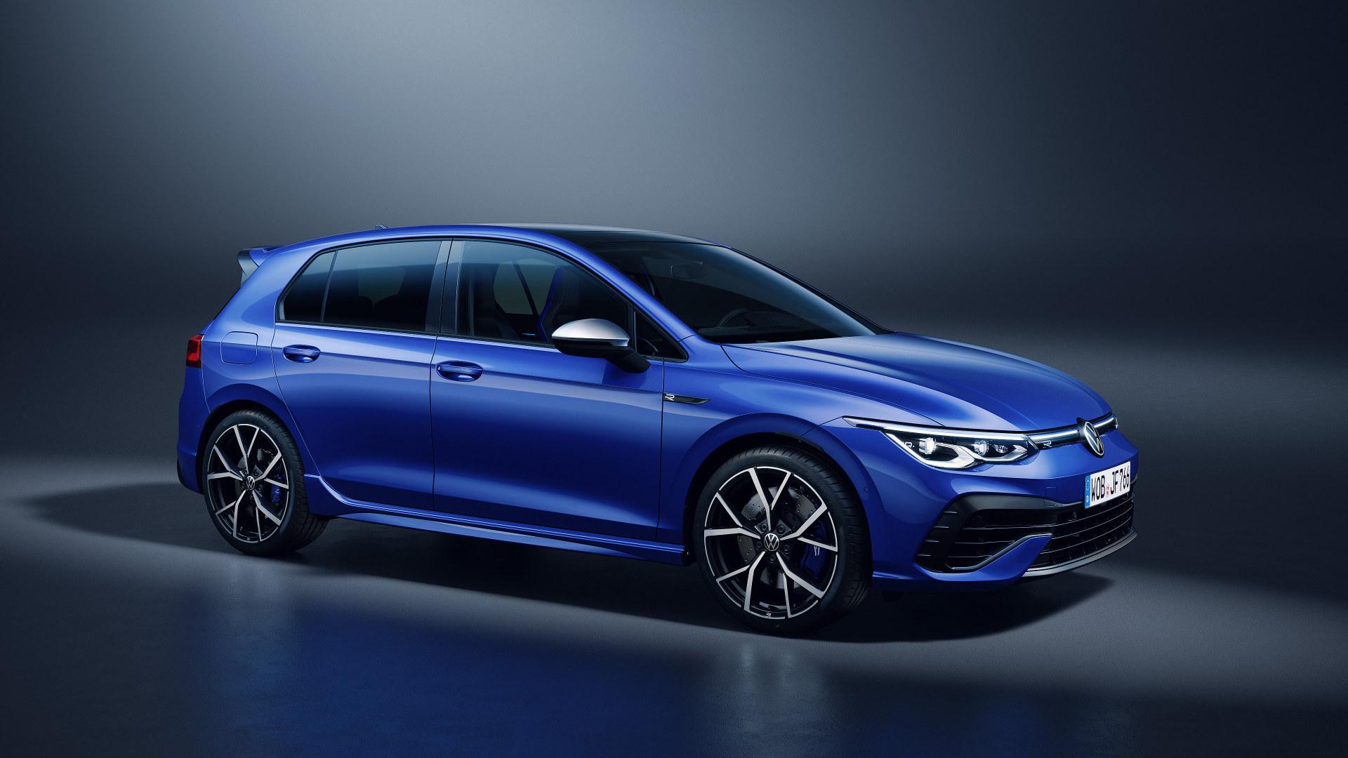 Синий автомобиль Volkswagen Golf R 2020 года на сером фоне