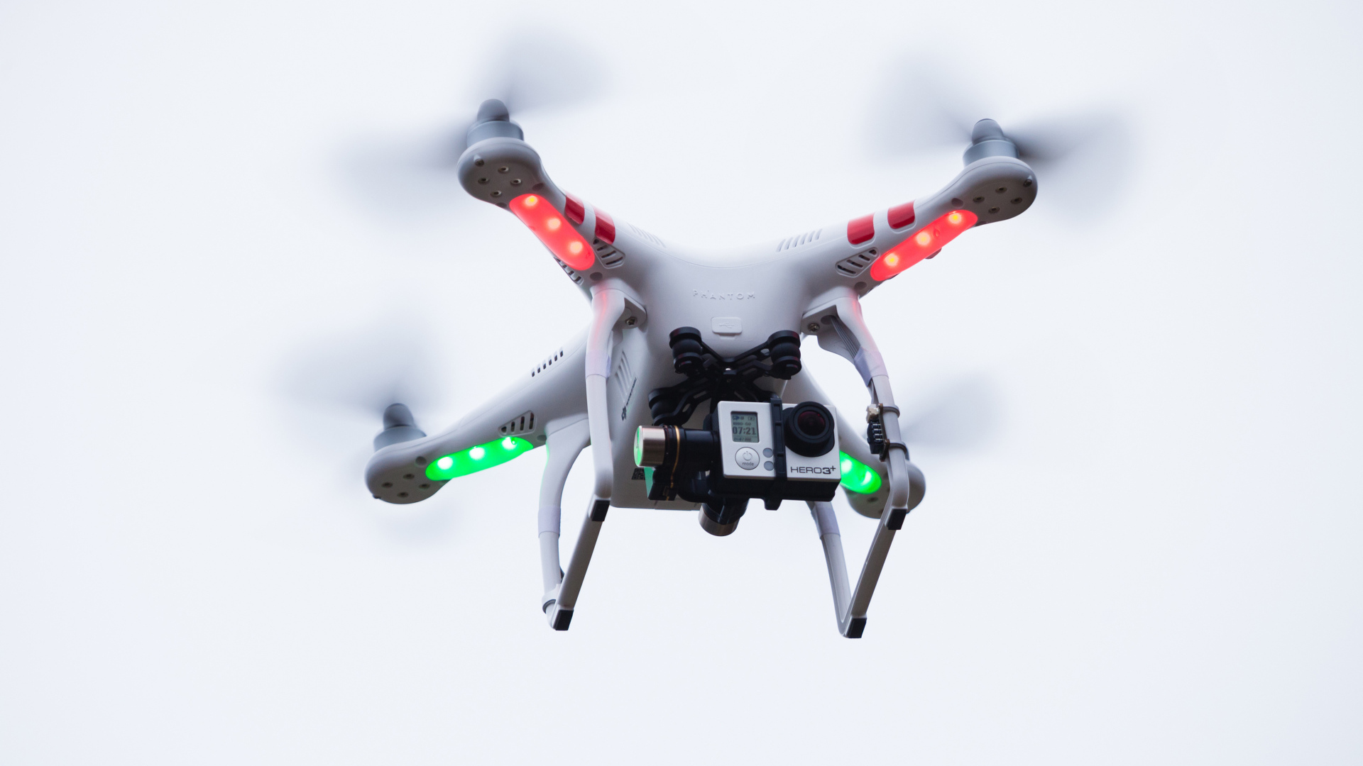 Квадрокоптер с видеокамерой на белом фоне