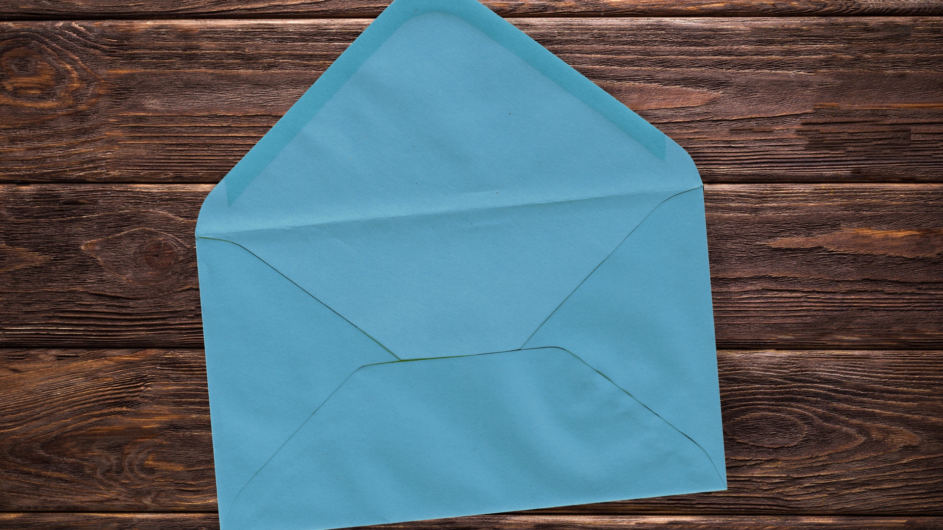 Голубой бумажный конверт на деревянном фоне