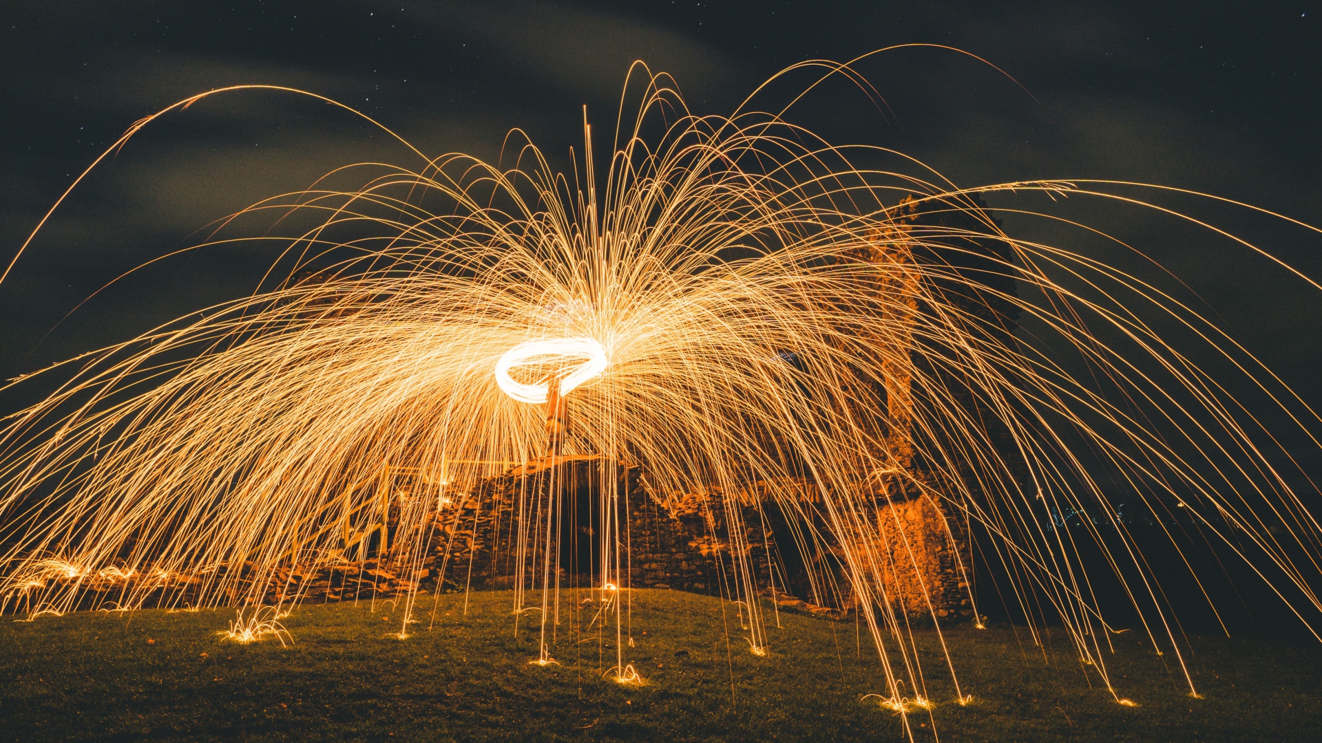 Яркие огненные искры фейерверка на развалинах