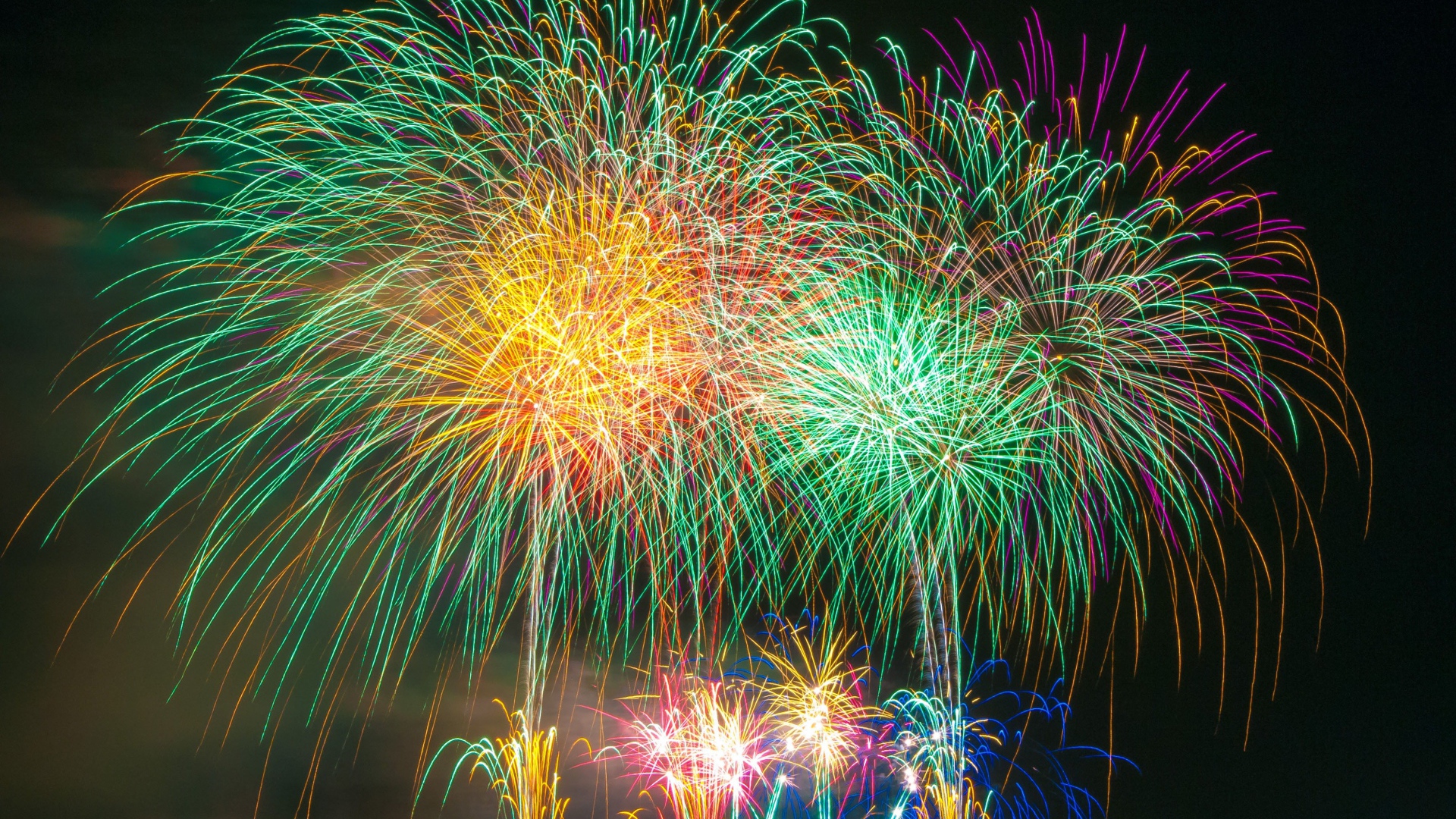 Яркий разноцветный праздничный фейерверк в  небе над городом 