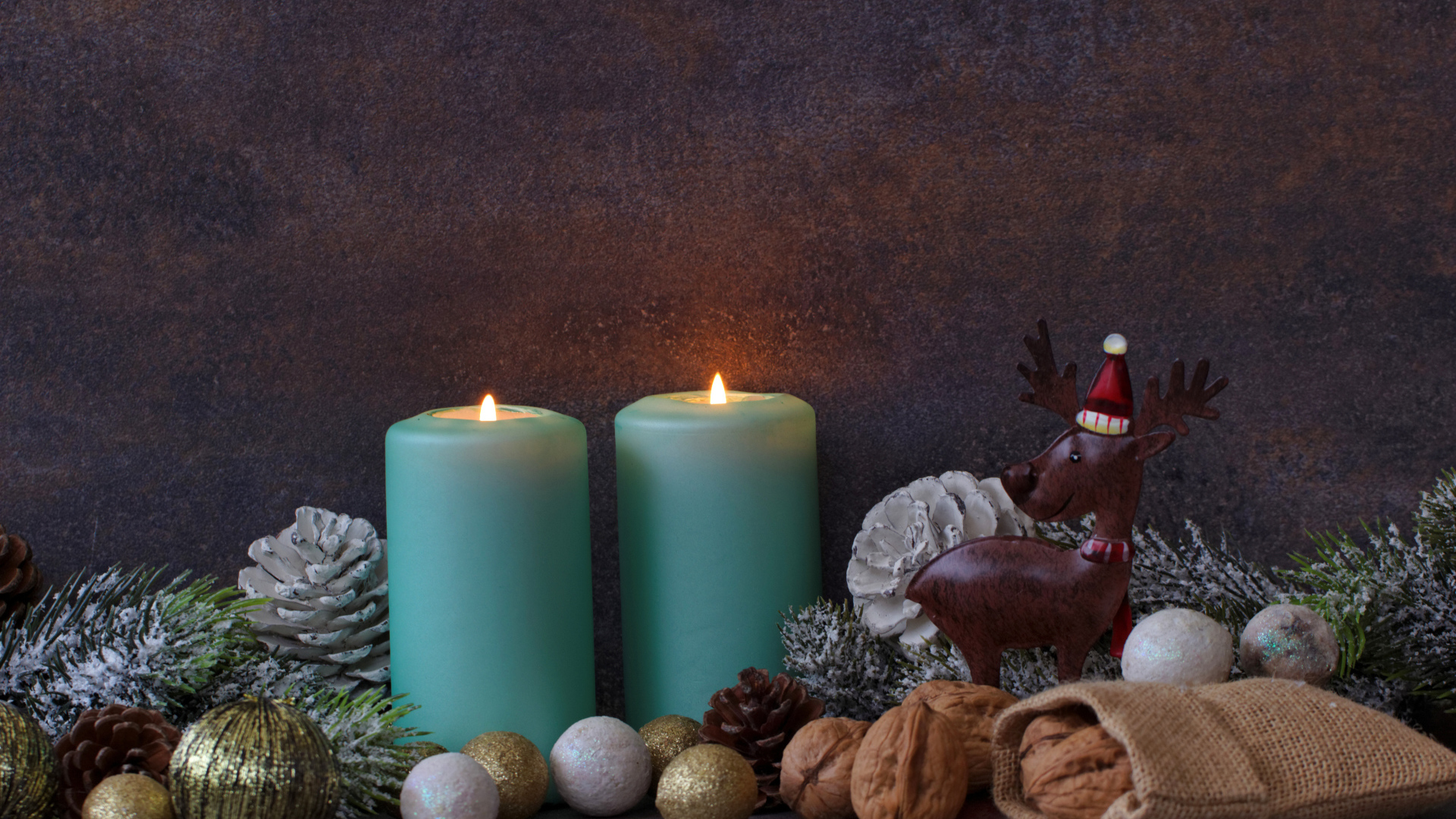 Зажженные свечи на фоне стены с декором